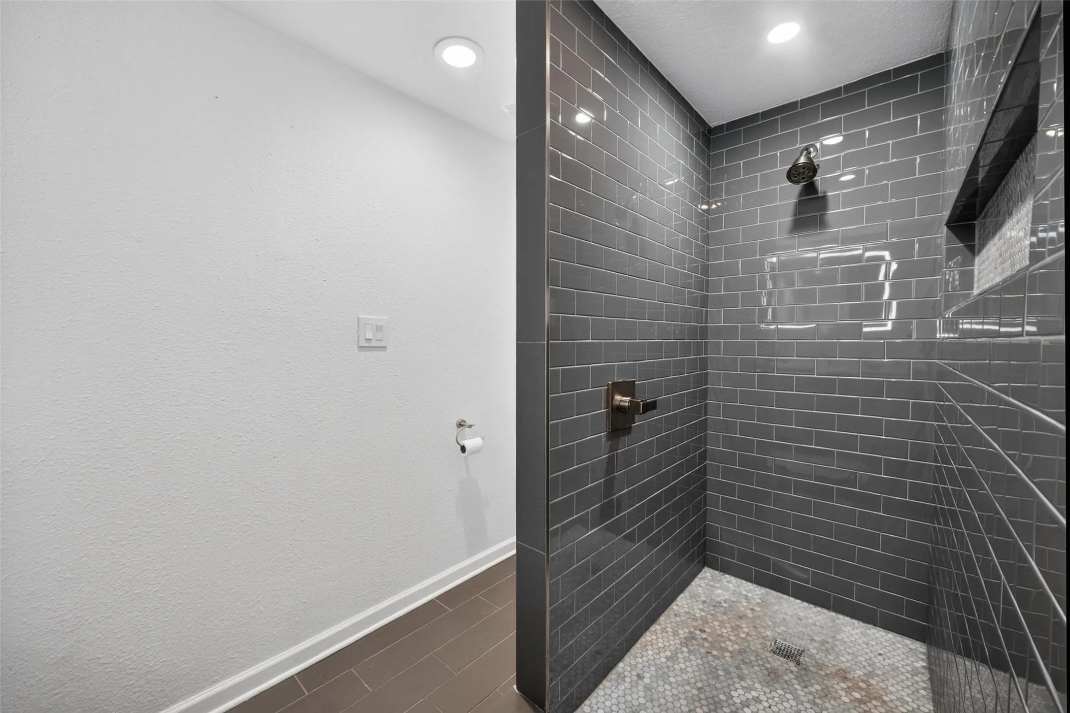 Walk-in shower with subway tile surround, mosaic tile floor, and recessed lighting