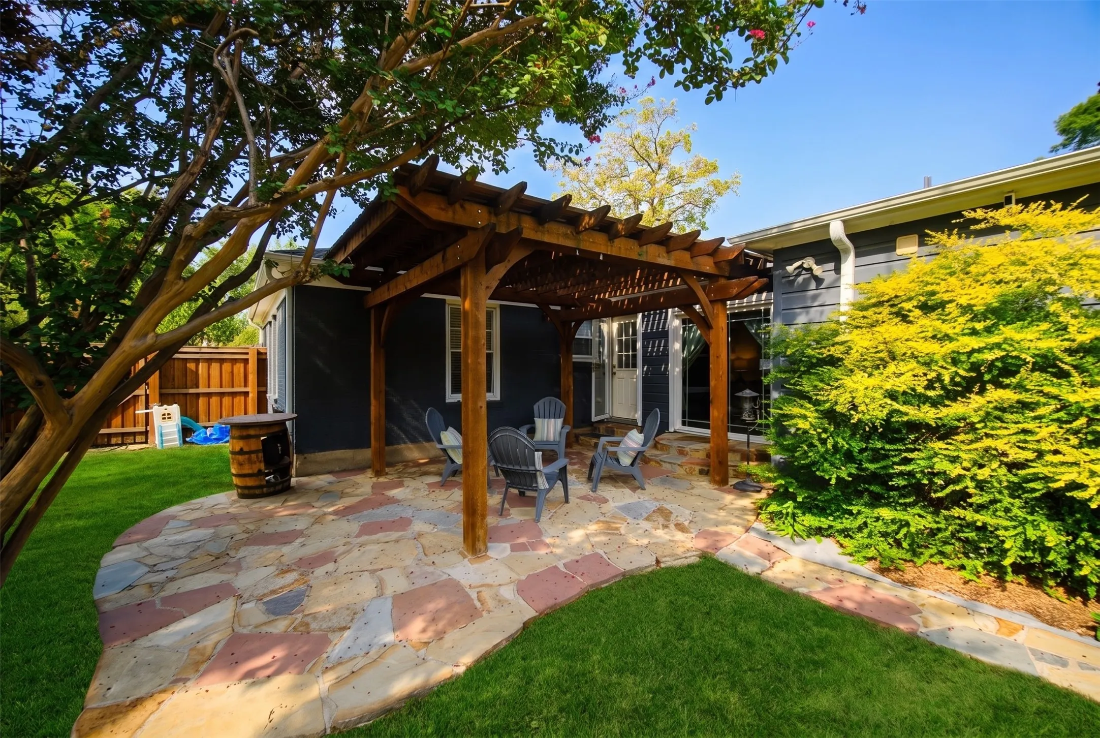 Flagstone patio with a wood pergola
