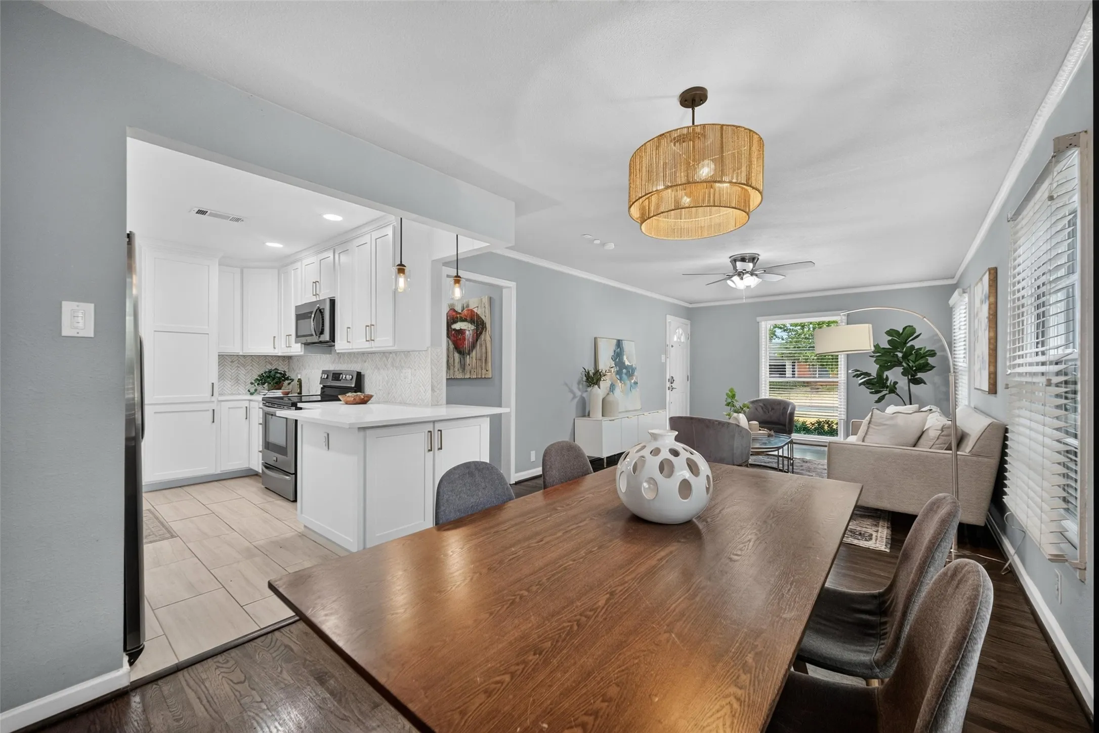 White shaker cabinetry, stainless steel appliances, and a kitchen island with seating