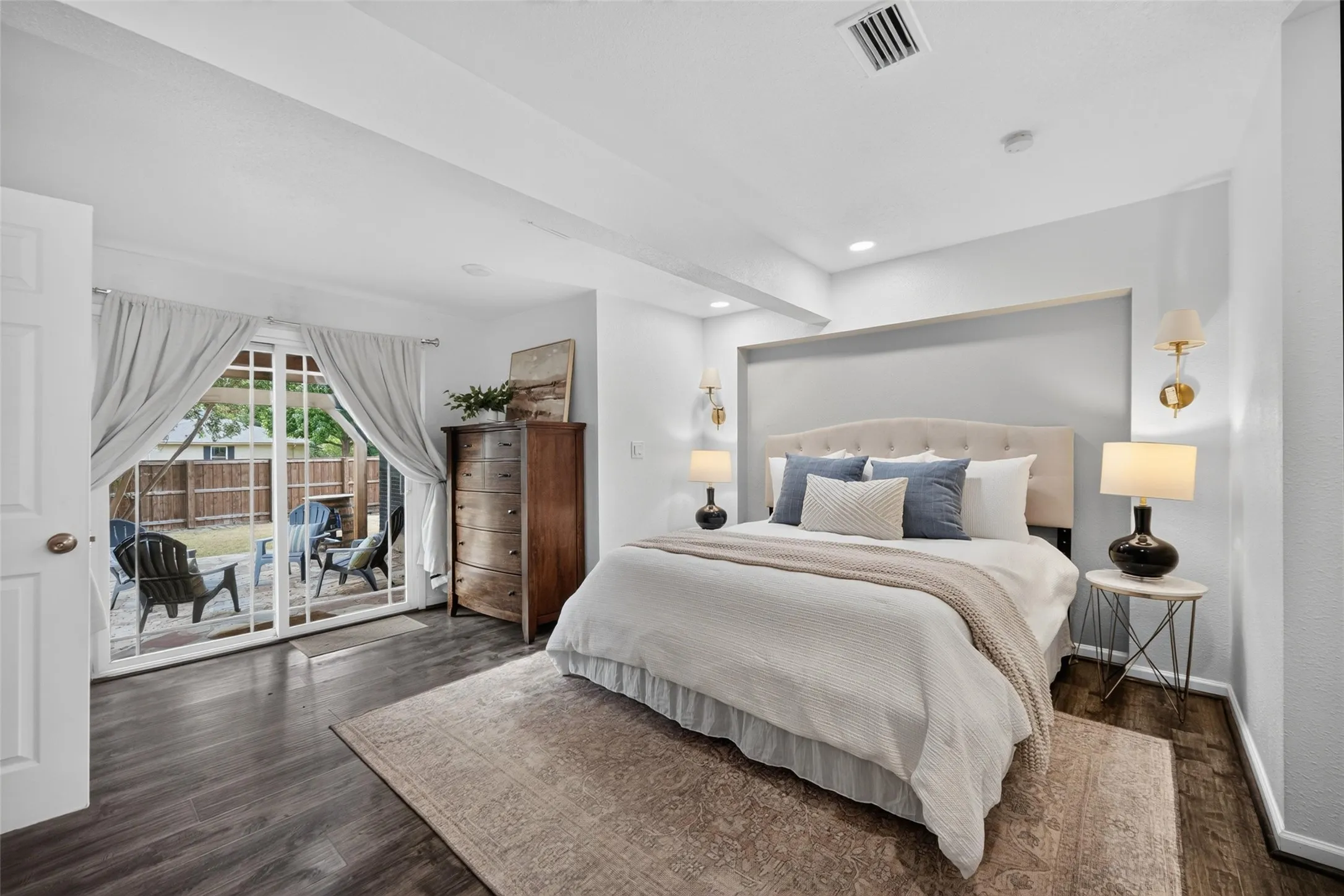 Wood-finish flooring, recessed lighting, and a built-in wall niche with sconces