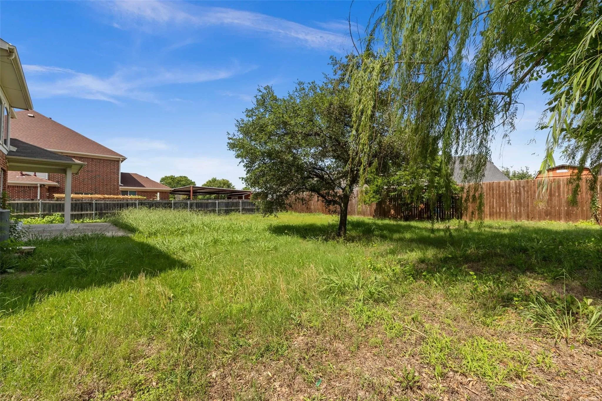 Expansive backyard with established trees and a privacy fence