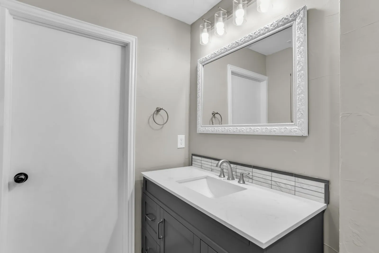 Vanity with integrated sink, white countertop, and brushed nickel faucet