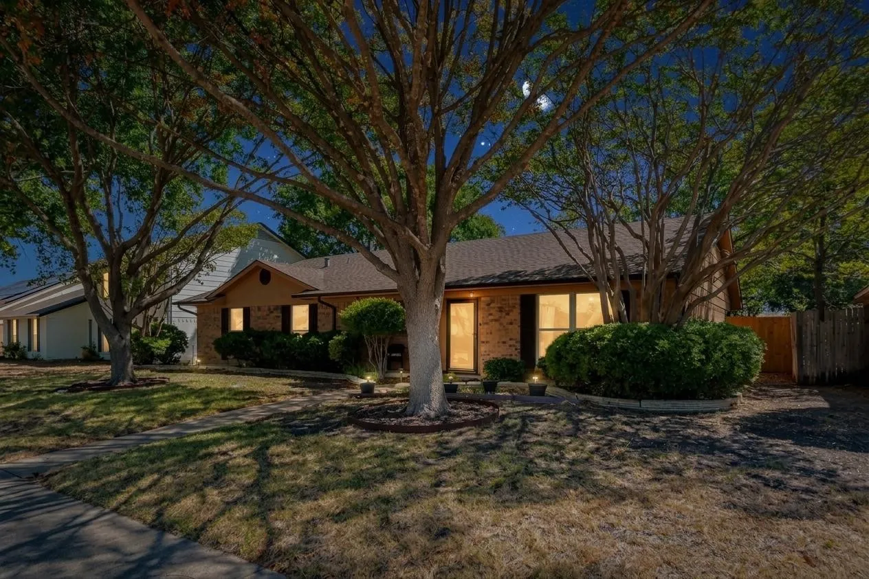 Brick exterior, mature trees, landscaped front yard, shingle roof, integrated exterior lighting