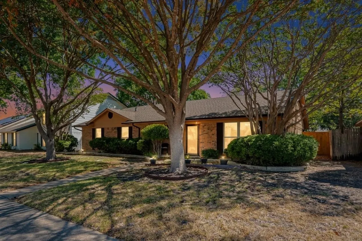 Brick exterior with a dark shingle roof