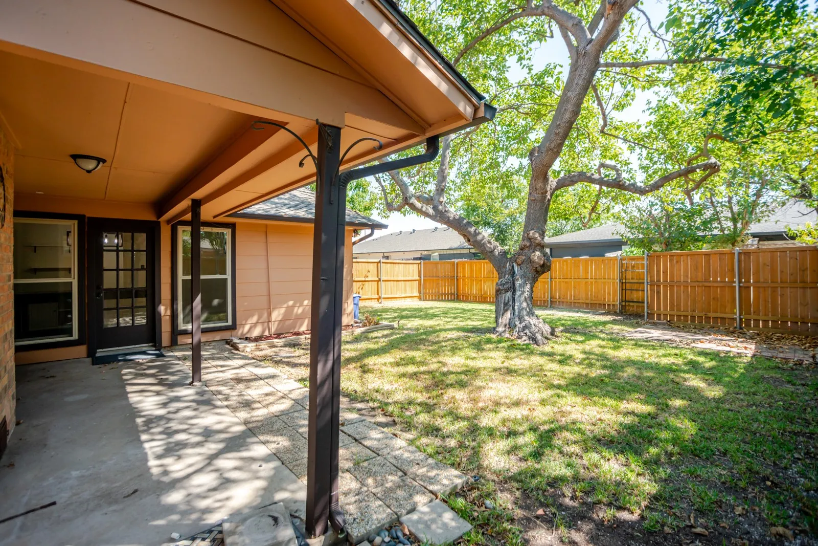 Covered patio with concrete and paver flooring