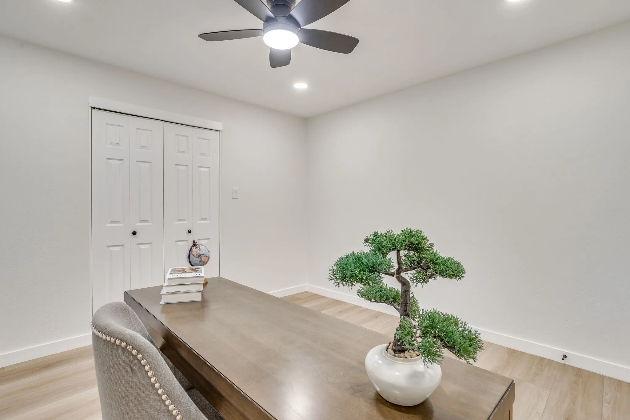 Recessed lighting, wood-finish flooring, ceiling fan with integrated lighting, and white bi-fold closet doors