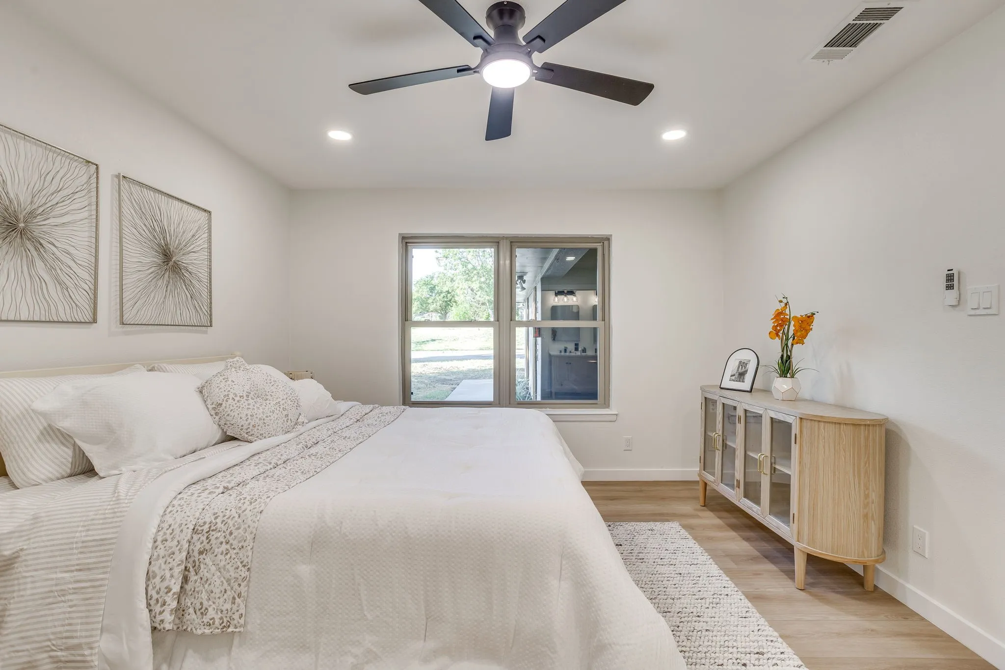 Recessed lighting, ceiling fan, wood-finish flooring, and a window with exterior views