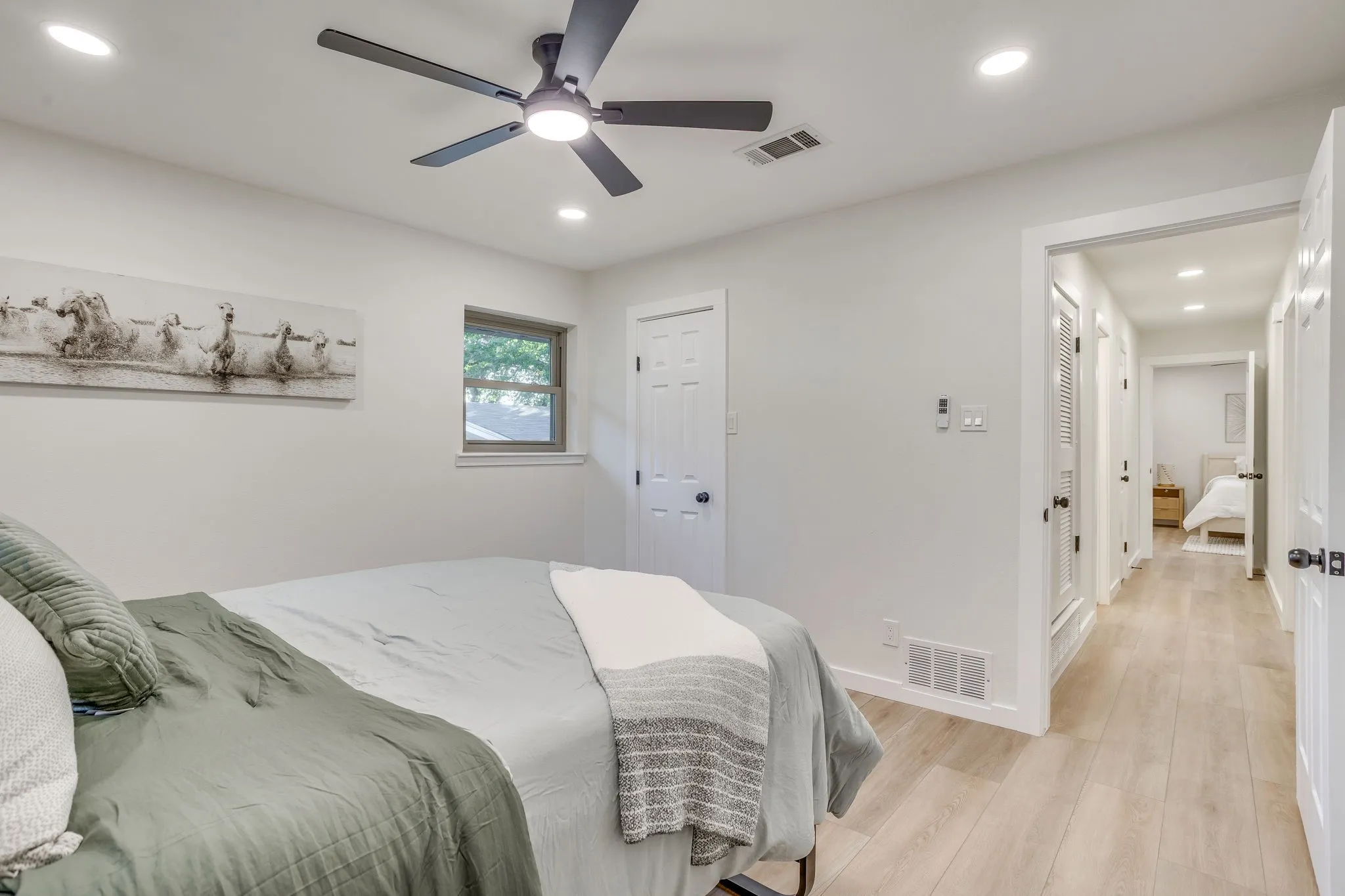 Light wood-finish flooring, recessed lighting, and a modern ceiling fan with integrated lighting
