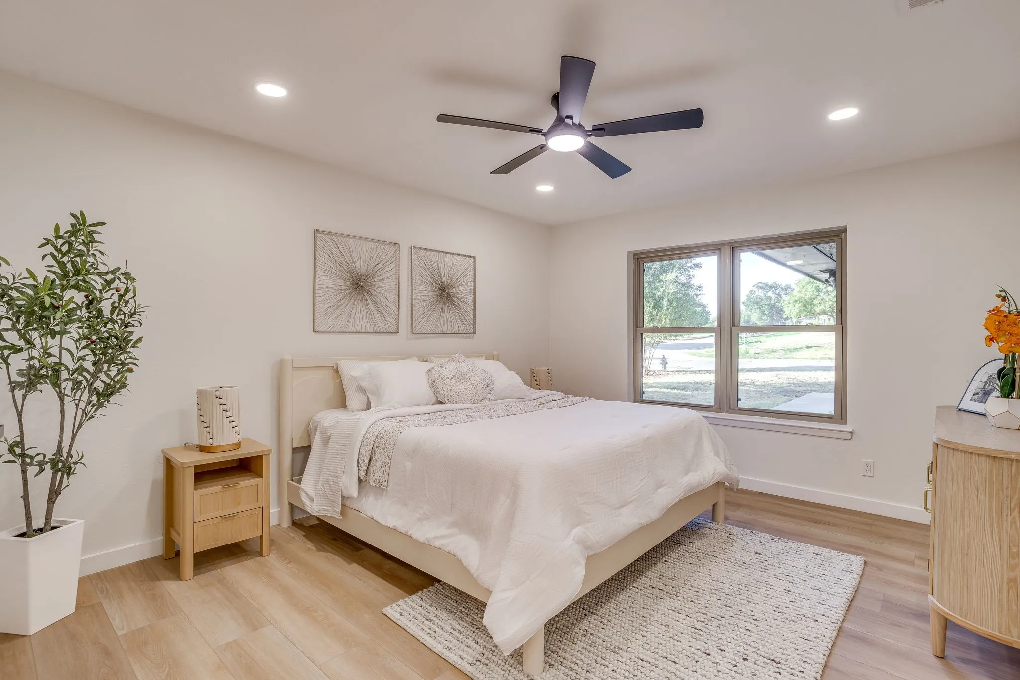 Recessed lighting, wood-finish flooring, a ceiling fan, and a window with a neutral frame