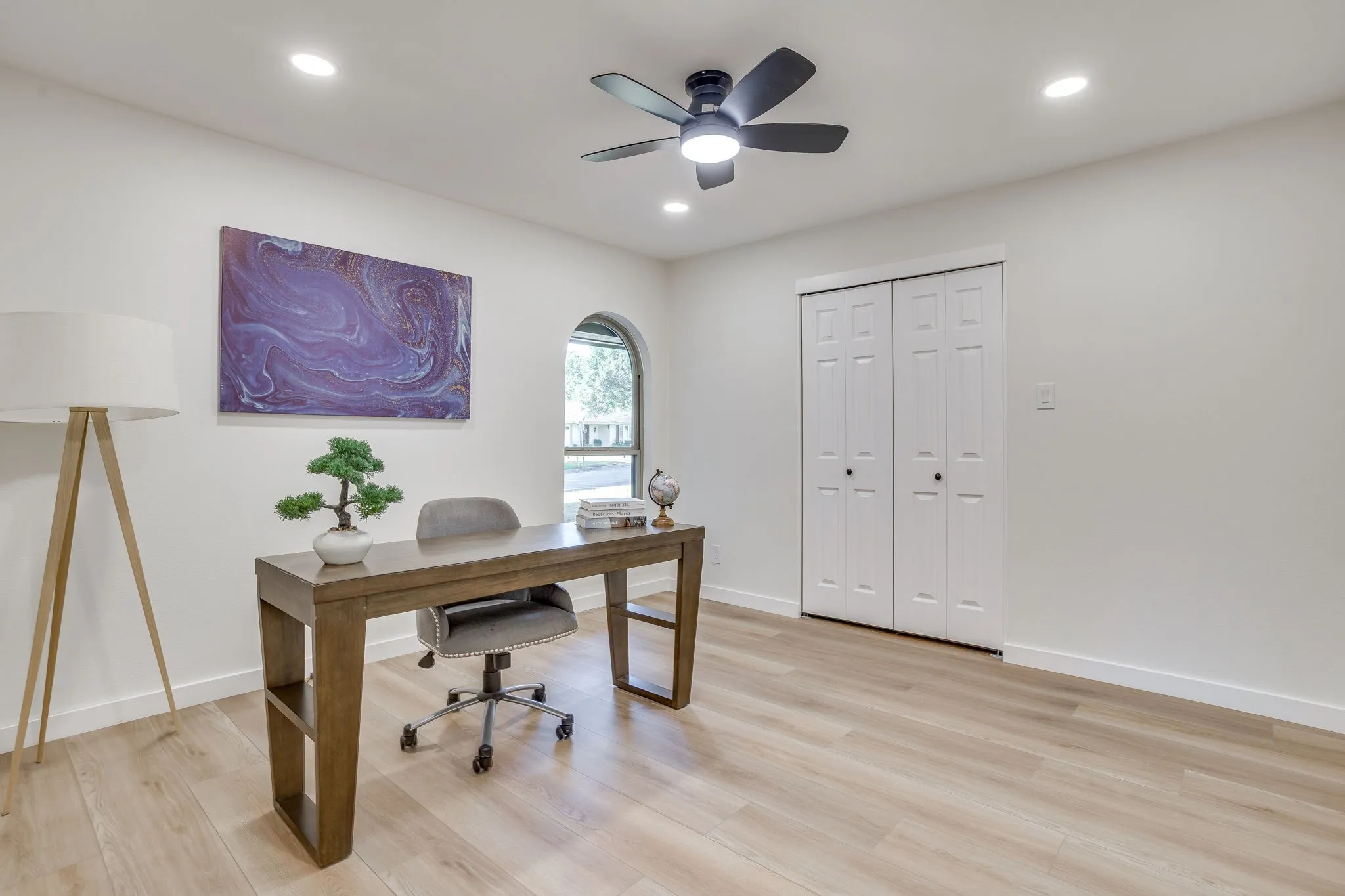 Recessed lighting, ceiling fan with integrated light, wood-finish flooring, arched window, and bi-fold closet doors