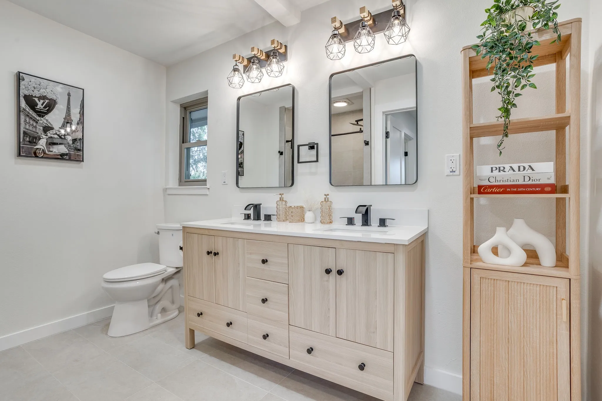 Dual sink vanity with light wood-finish cabinetry and black hardware