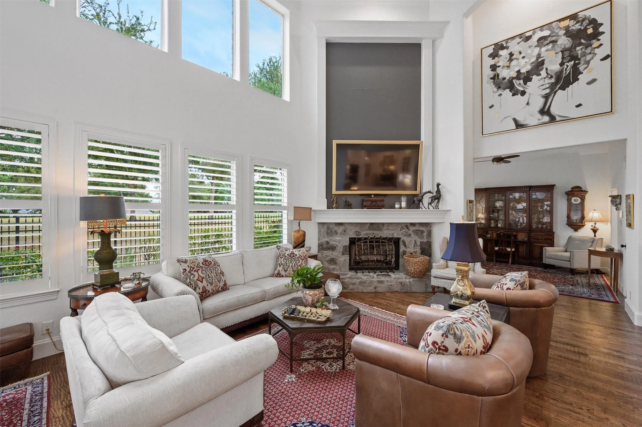 Two-story living area with a stone-clad fireplace and wood-finish flooring
