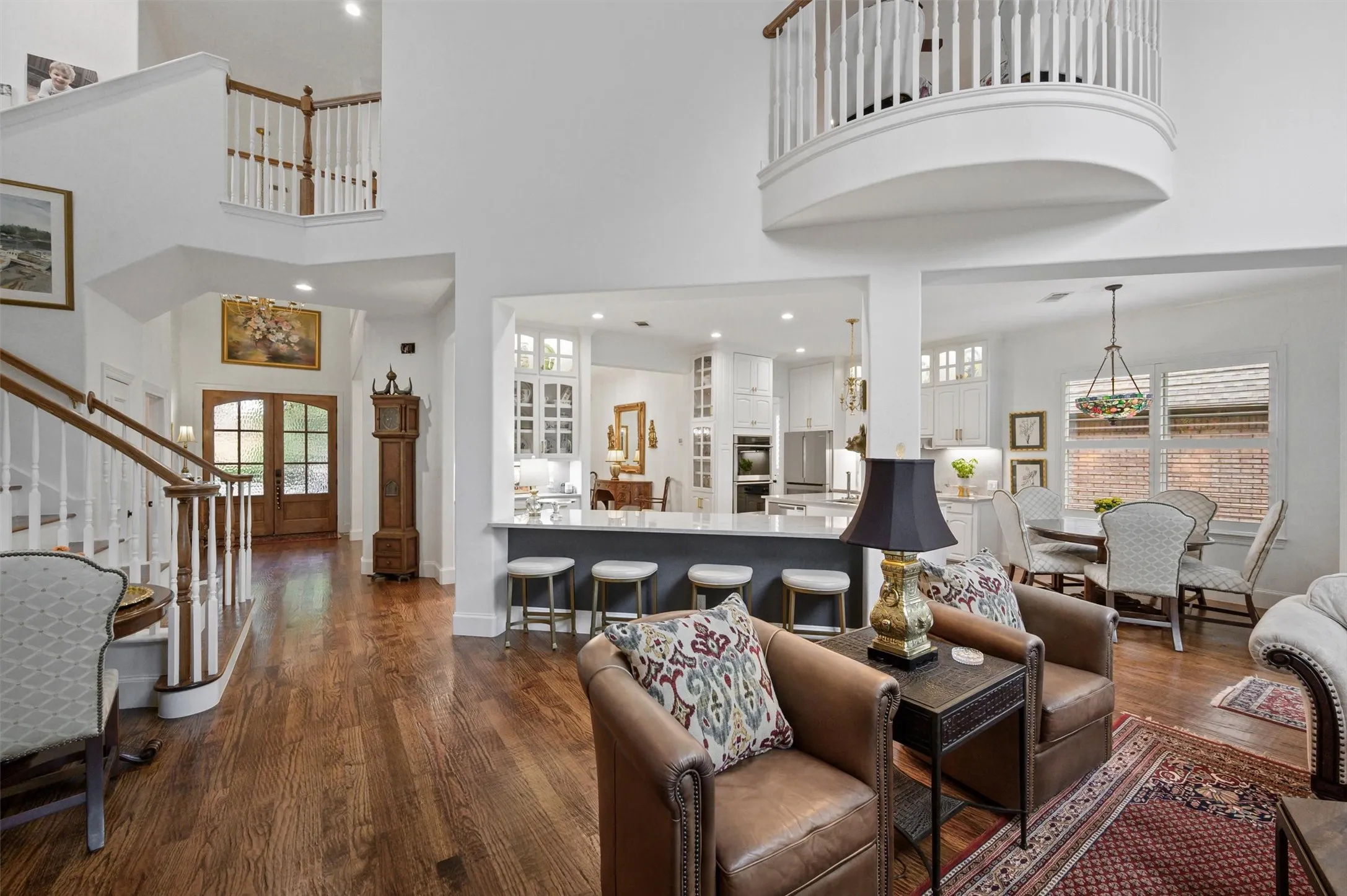 Two-story foyer with wood-finish flooring, a grand staircase, and a second-level balcony