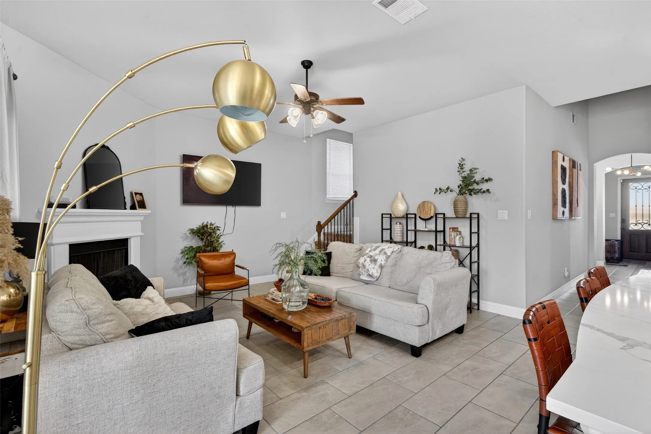 Living area featuring a fireplace with a mantel, ceiling fan, and tile flooring