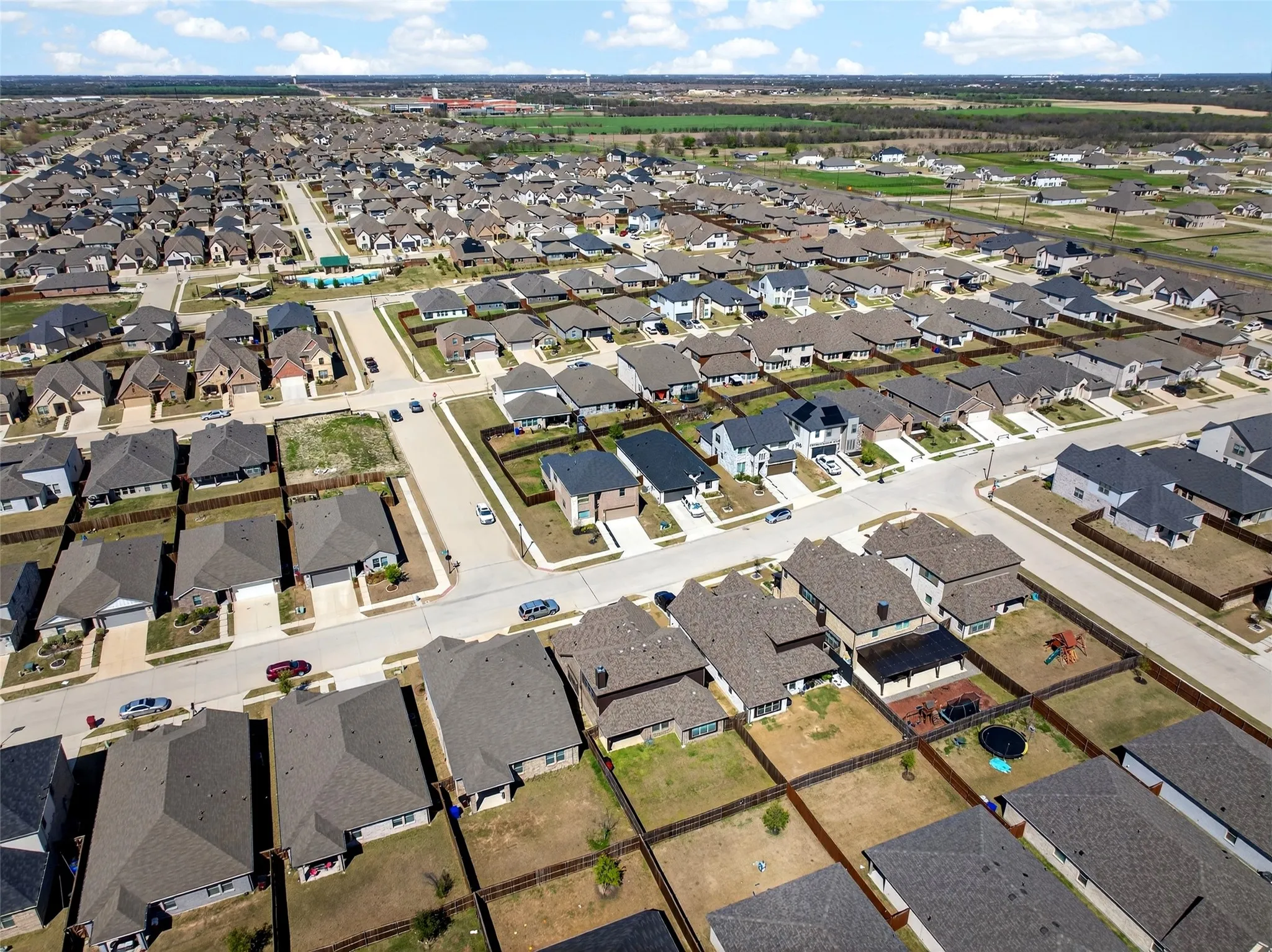 Expansive residential development featuring numerous single-family homes, paved streets, and varied property sizes