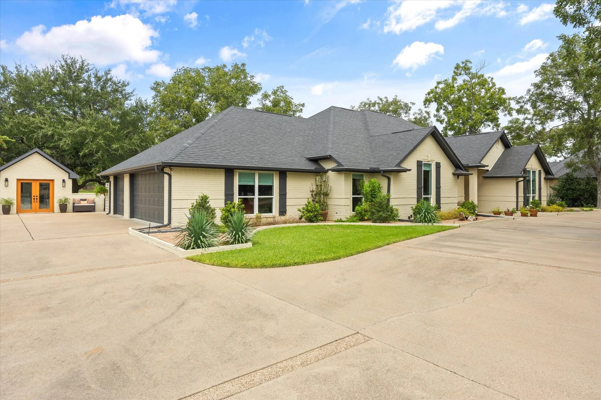 Oversized Three Car Garage Featuring Work Bench and Cabinets, Epoxy Floor and Storage Closet.  Detached Double Door Workshop with Epoxy Floor, Cabinets and Split HVAC Unit for Year-Round Enjoyment!