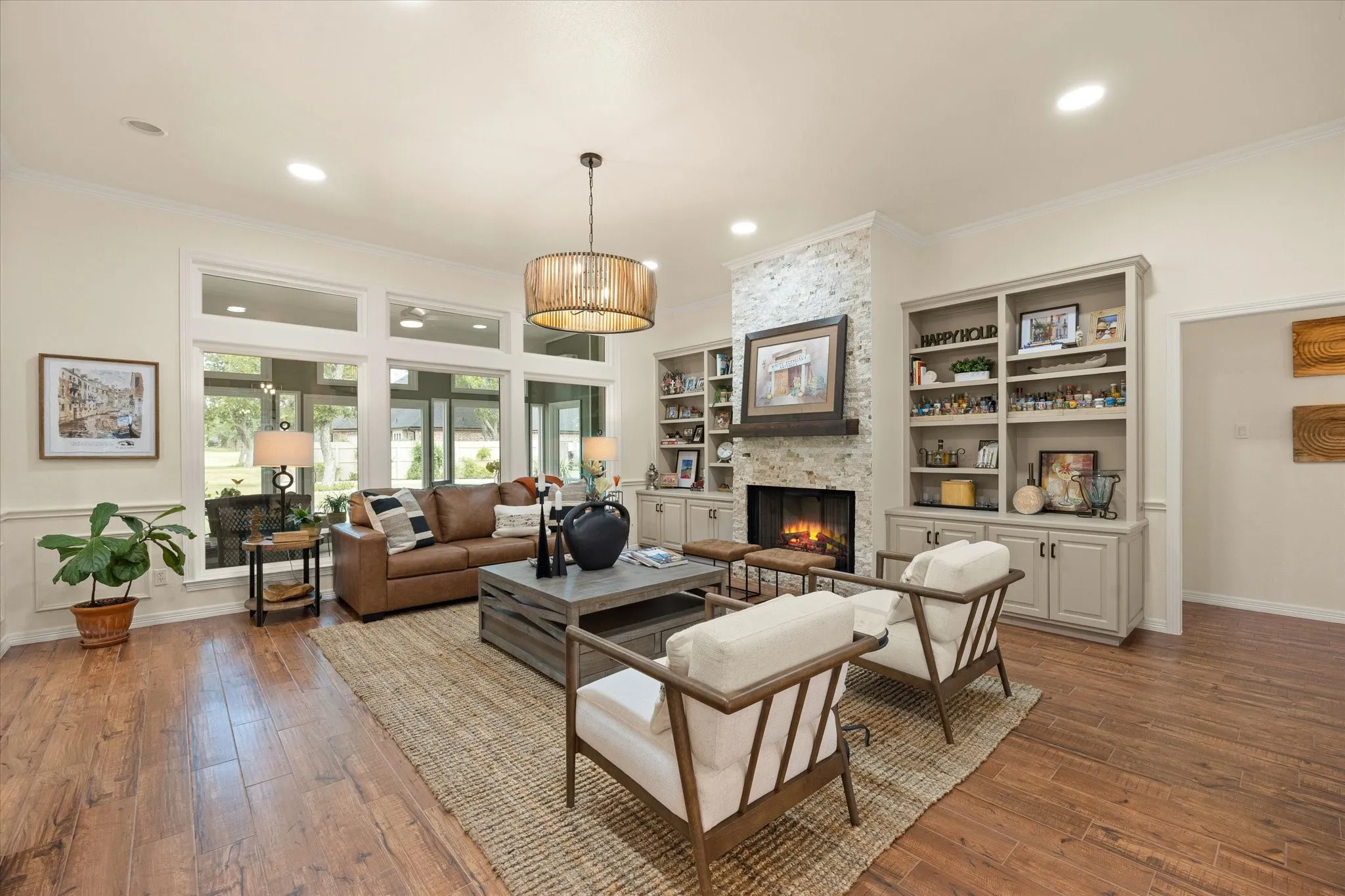  A Great Great Room! Gas Fireplace Featuring Stacked Stone, Custom-Built Cabinets and Bookcases.  Designer Light Fixture Completes this space,