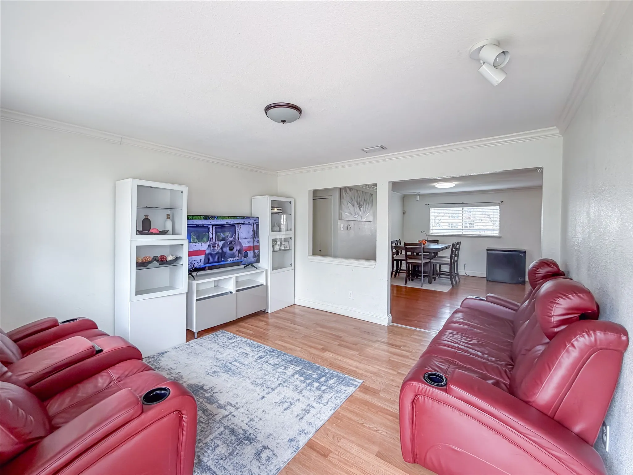Light wood-finish flooring extends throughout, complemented by white walls and ceiling