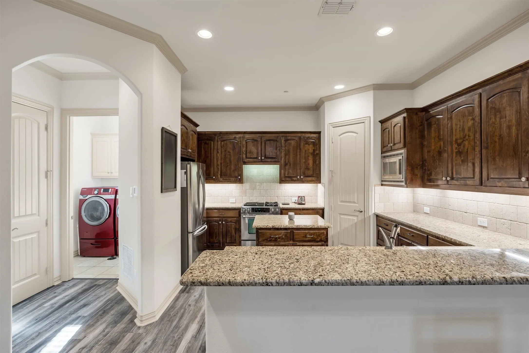 Gourmet kitchen with wood-finish cabinetry, granite countertops, and stainless steel appliances