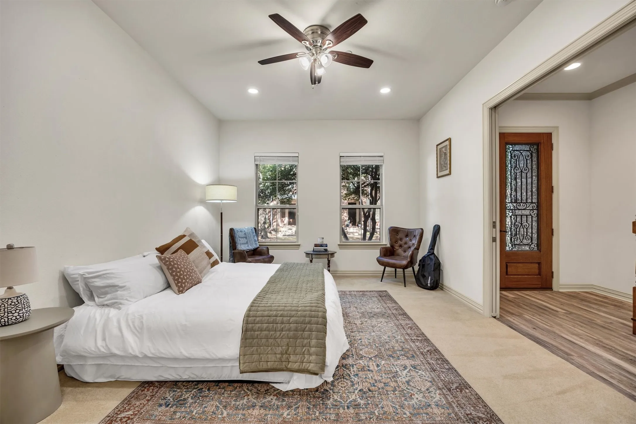 Vaulted ceiling with a ceiling fan, recessed lighting, and two windows providing natural illumination