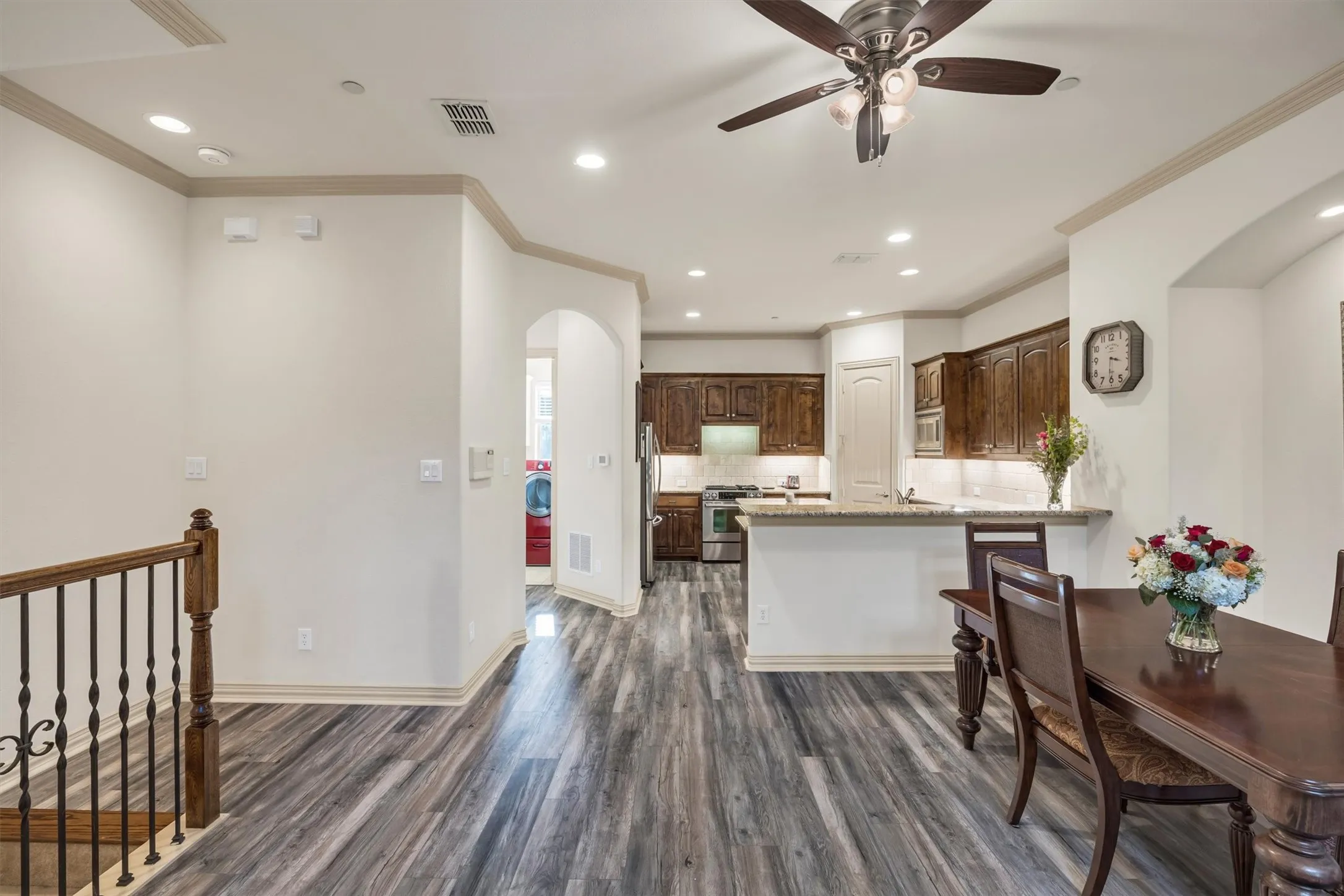 Open-concept living area with wood-finish flooring, recessed lighting, and a ceiling fan