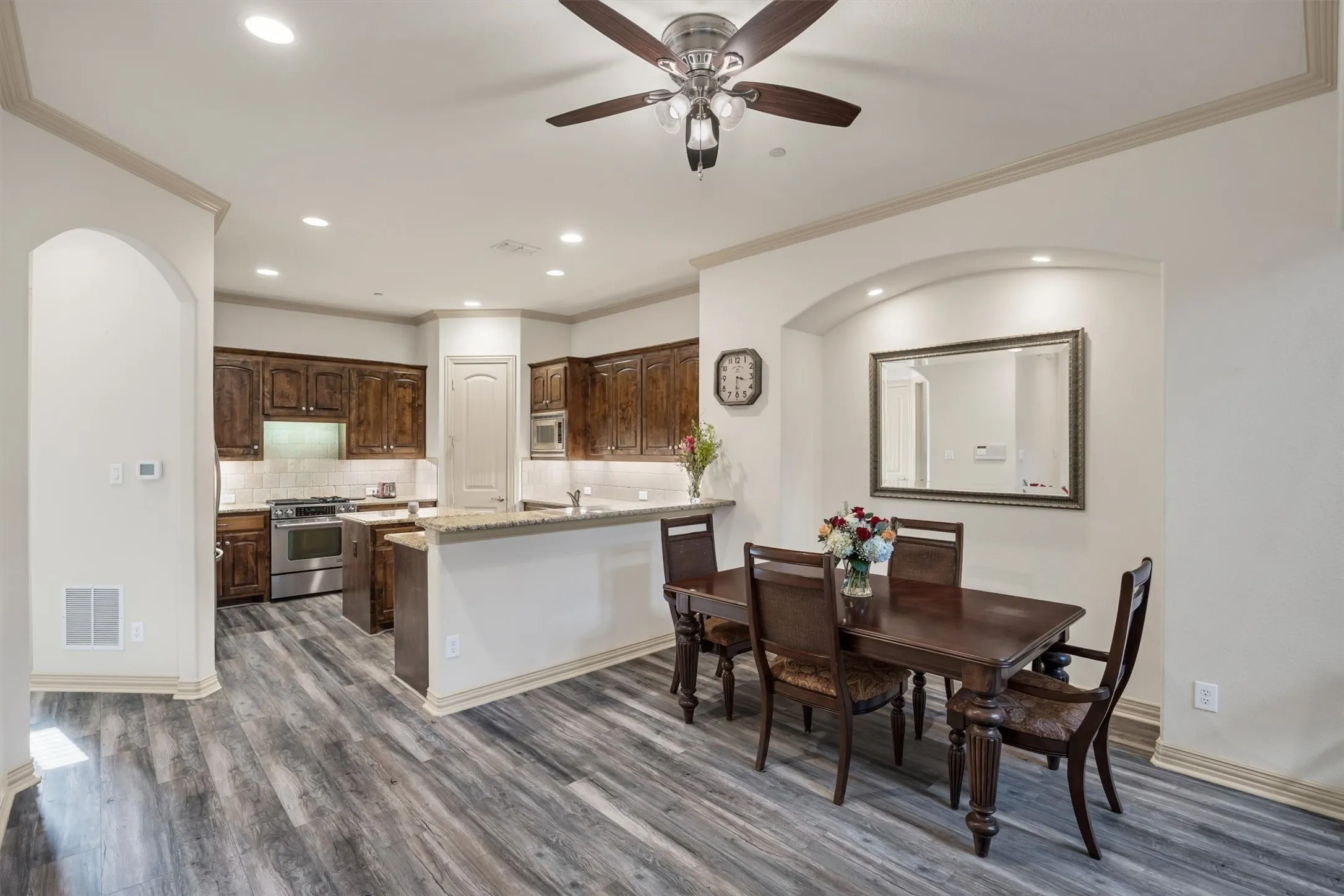 Kitchen and dining area featuring wood-finish flooring, recessed lighting, and a ceiling fan