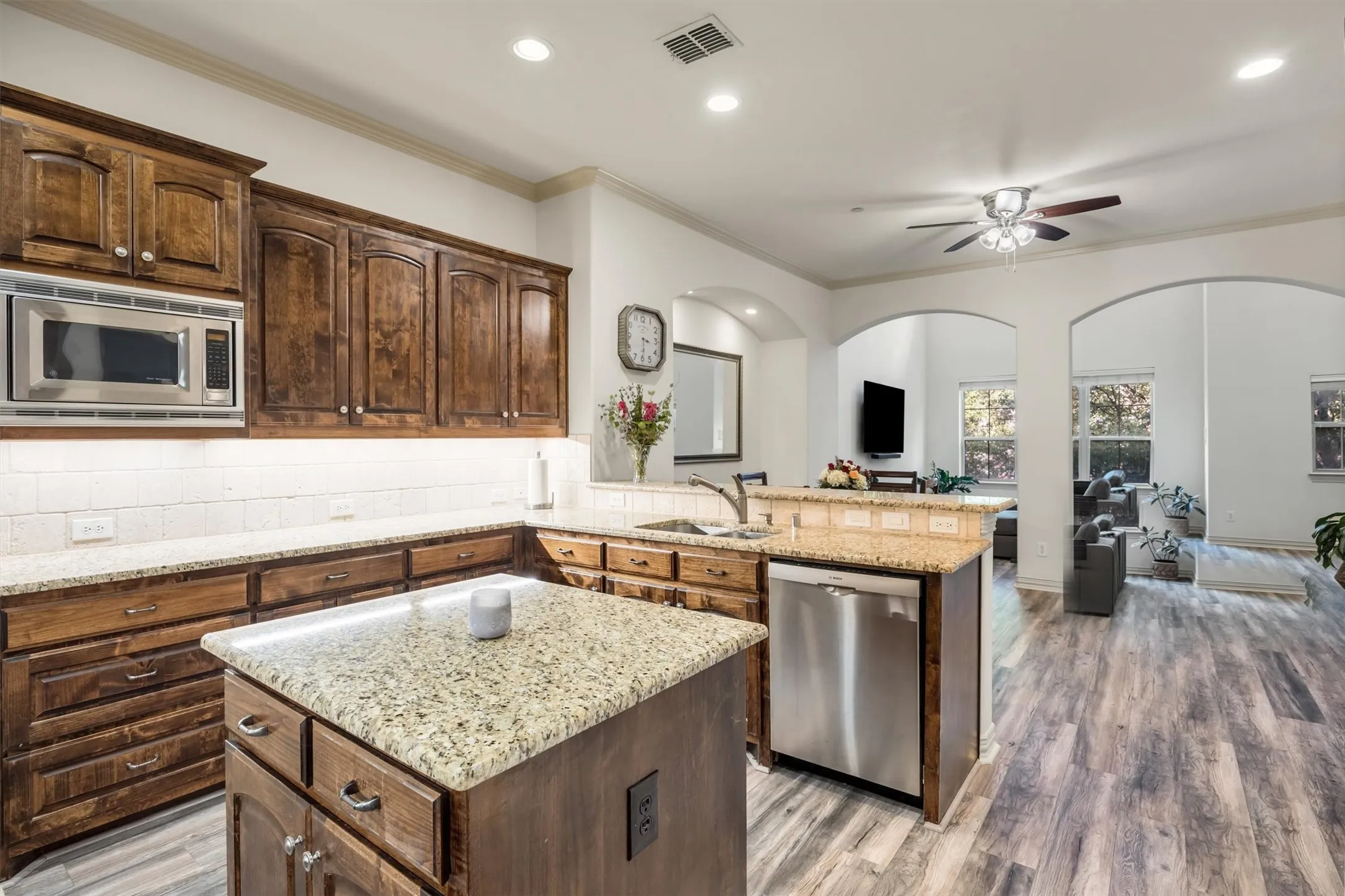 Kitchen featuring wood cabinetry, granite countertops, stainless steel appliances, and a central island