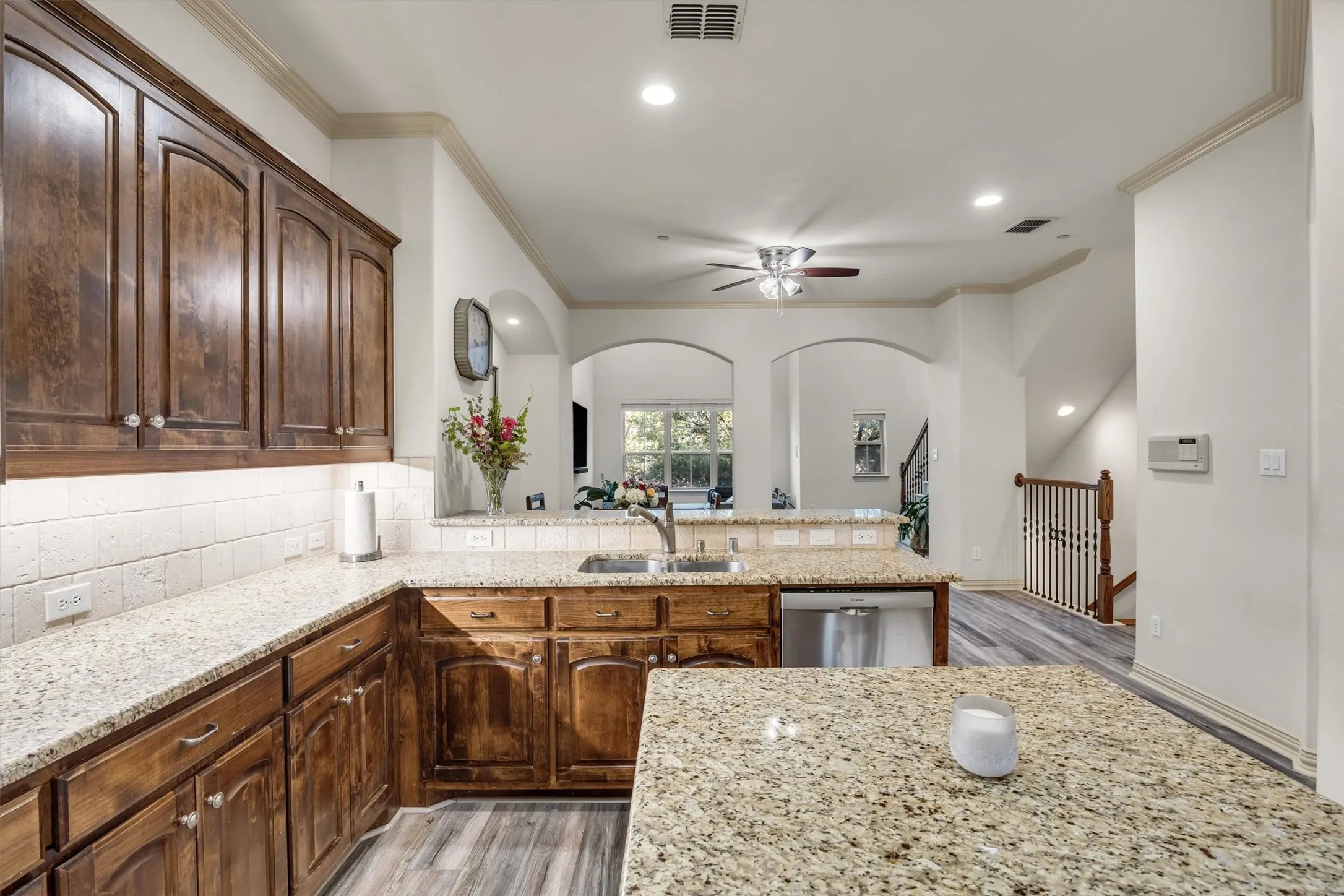 Kitchen featuring wood cabinetry, light-toned countertops, a tile backsplash, recessed lighting, and stainless steel appliances
