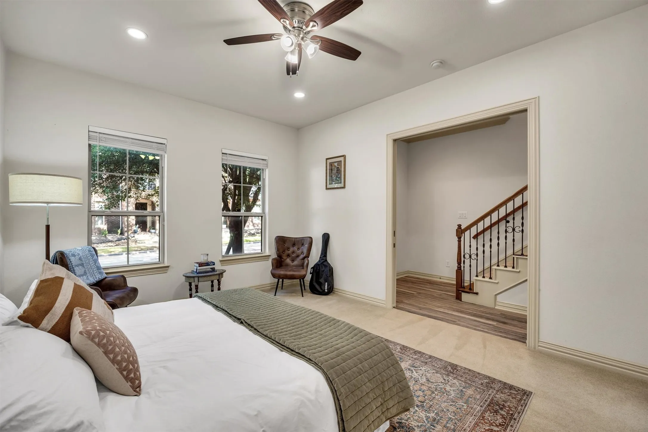 Recessed lighting, ceiling fan with light fixture, dual windows, carpeted flooring, and wood-finish flooring