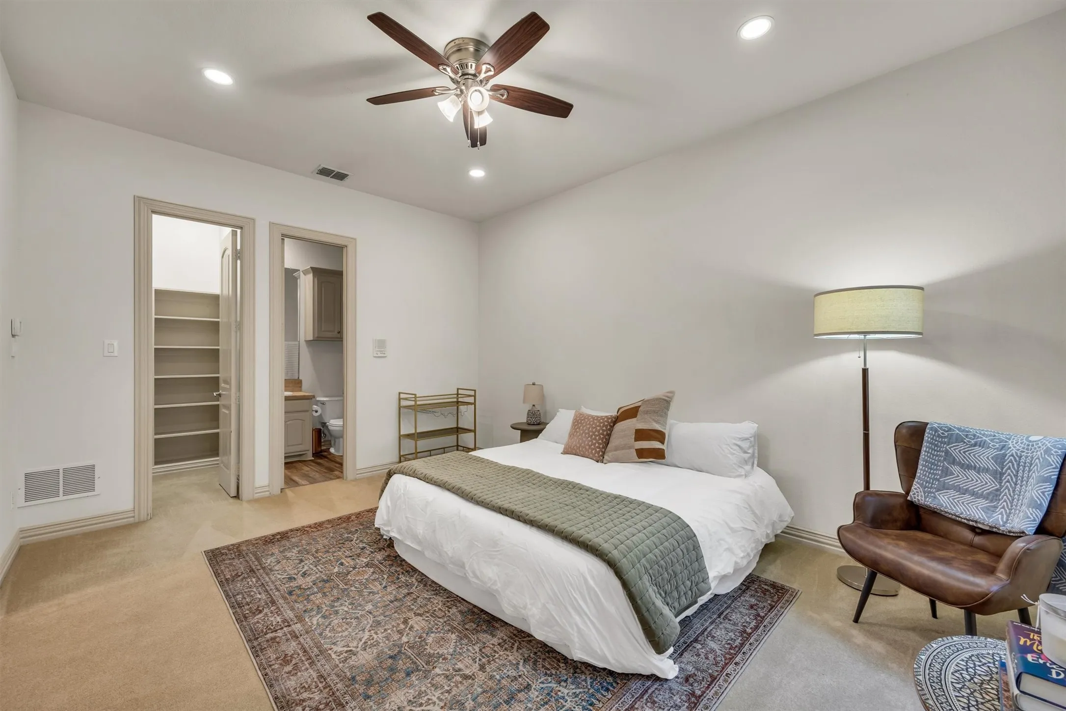Recessed ceiling lighting, ceiling fan with integrated lighting, carpeted flooring, built-in shelving, and wood-finish flooring in the bathroom