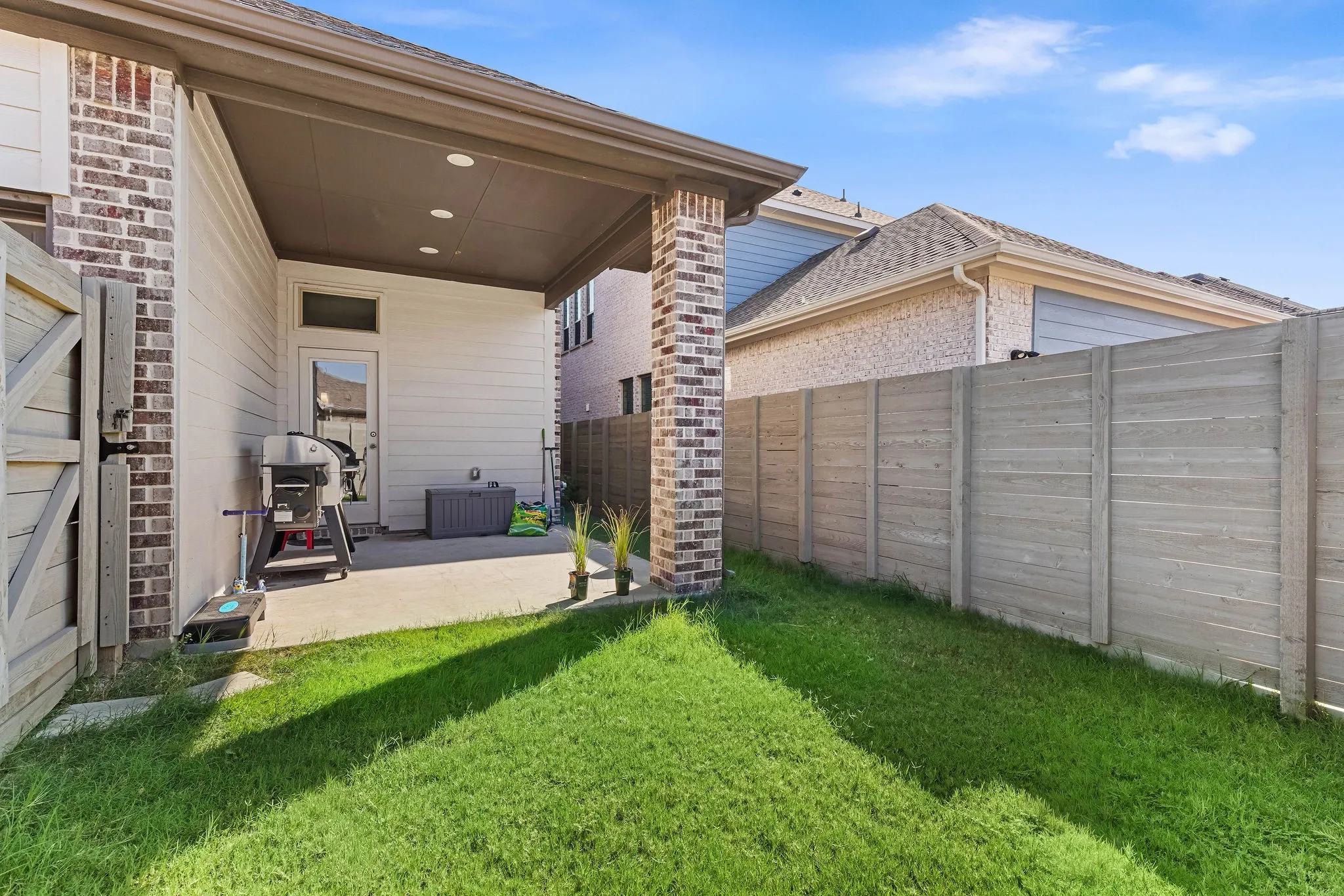 Covered patio with recessed lighting, concrete flooring, and a brick support column