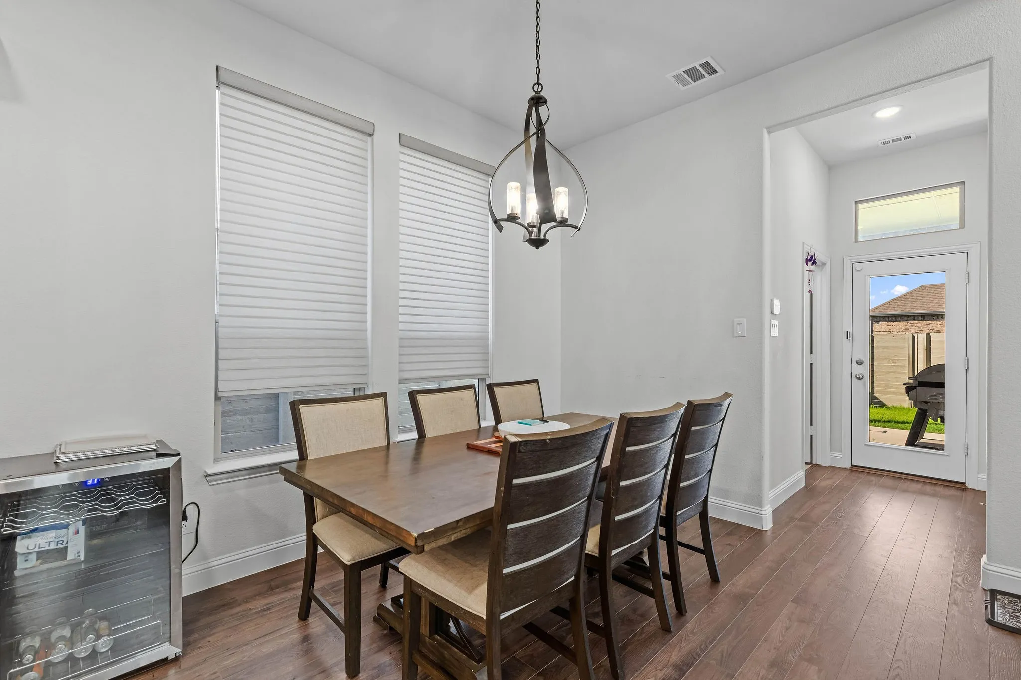 Hardwood-finish flooring, recessed lighting, and a prominent chandelier