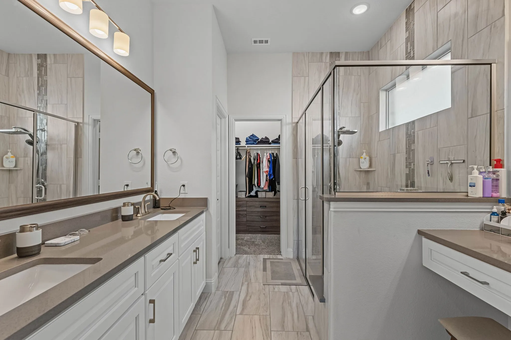 Dual vanity with undermount sinks, stone countertops, and individual storage