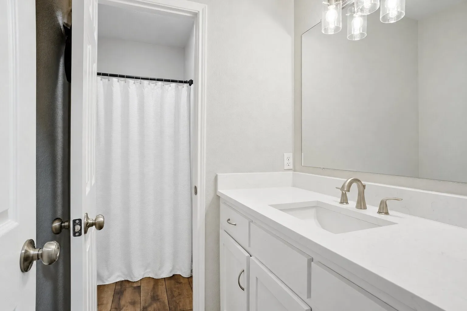 Hallway full bathroom with a quartz-topped vanity and a separate private area for the toilet and tub-shower combination. Photos have been AI enhanced for presentation; no material property features were altered.