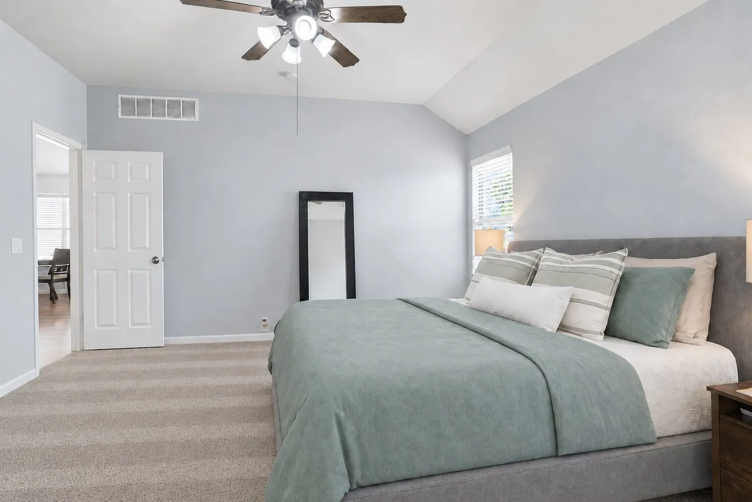 Another view of the spacious primary bedroom, highlighting its vaulted ceiling, natural light, and generous floor space. Photos have been AI enhanced for presentation; no material property features were altered.