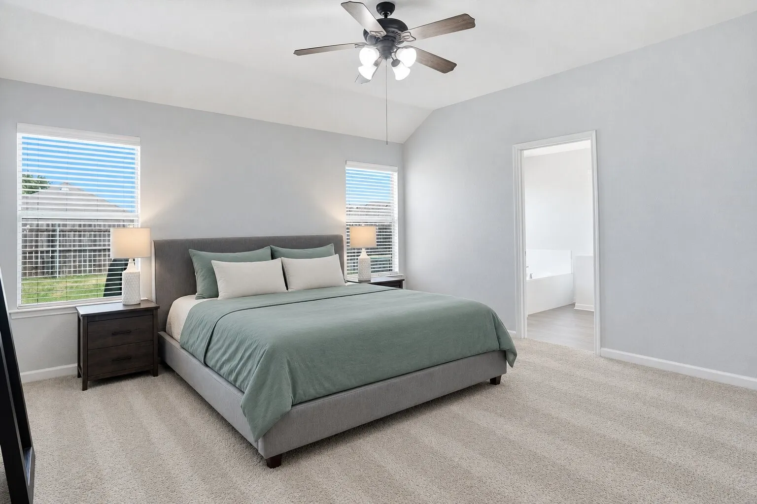 Spacious primary bedroom featuring a vaulted ceiling, abundant natural light, and direct access to the en suite bathroom. Photos have been AI enhanced for presentation; no material property features were altered.