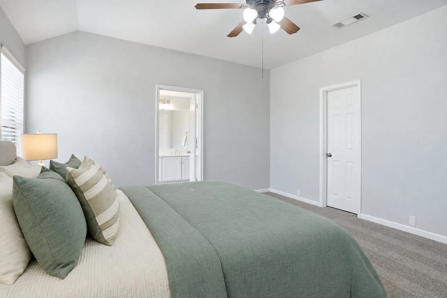 Primary bedroom with a vaulted ceiling, generous floor space, and convenient access to the en suite bathroom and walk-in closet. Photos have been AI enhanced for presentation; no material property features were altered.