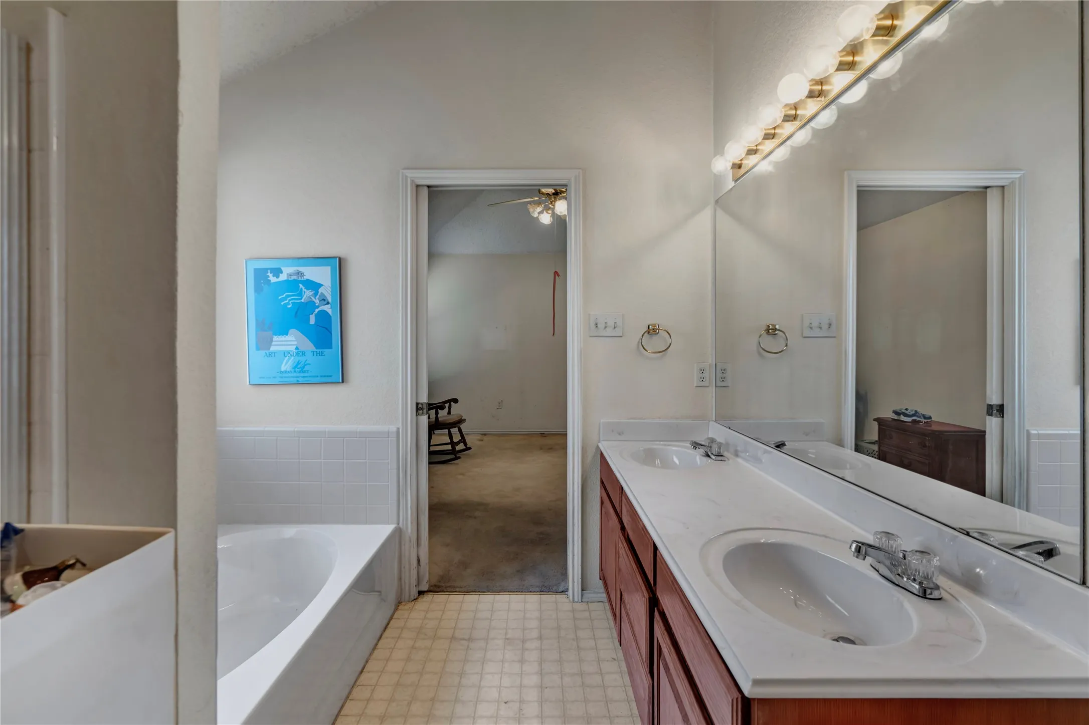 Dual vanity with integrated sinks, expansive mirror, and overhead strip lighting