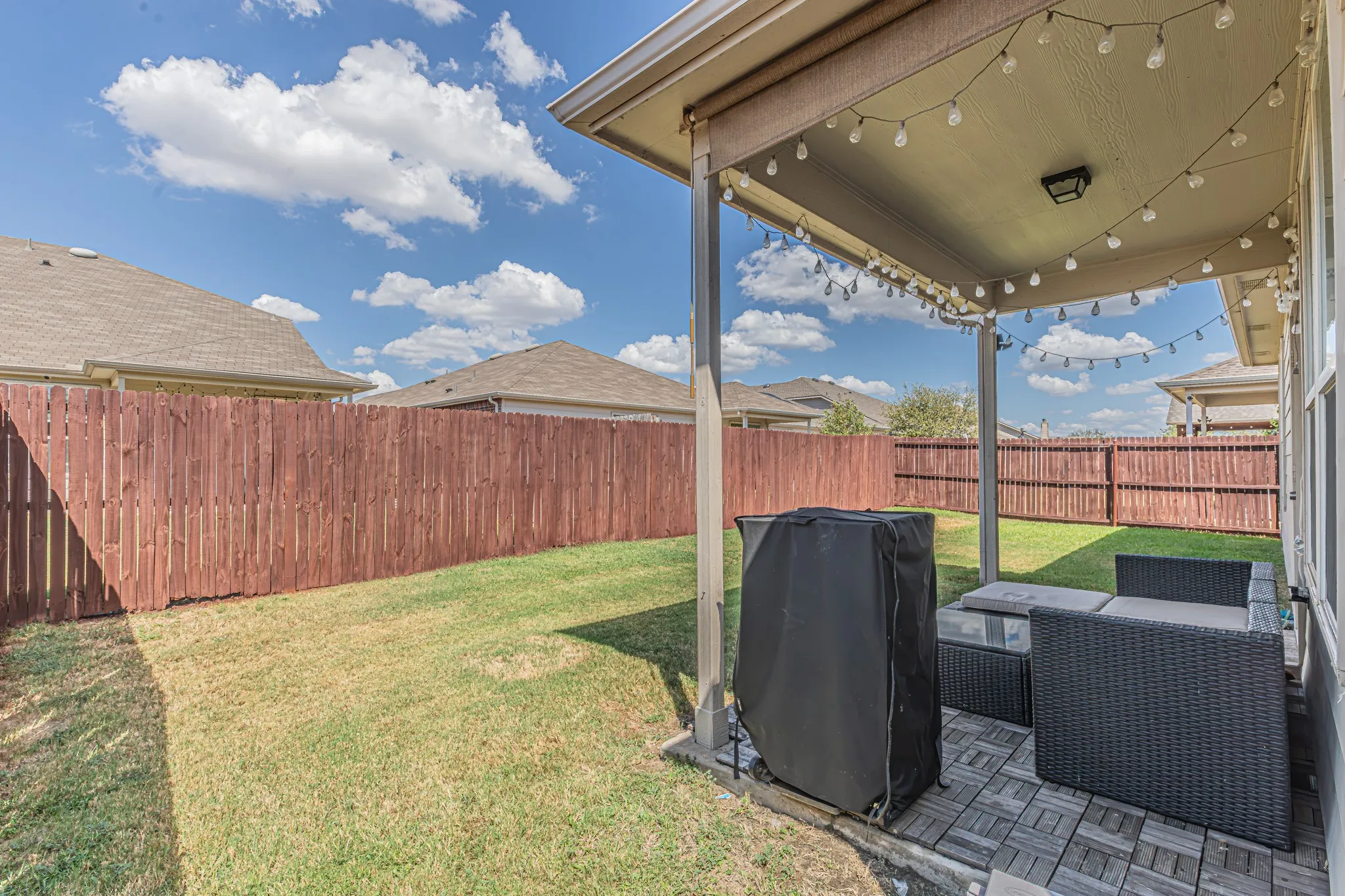 Covered patio with room for seating and a grill.