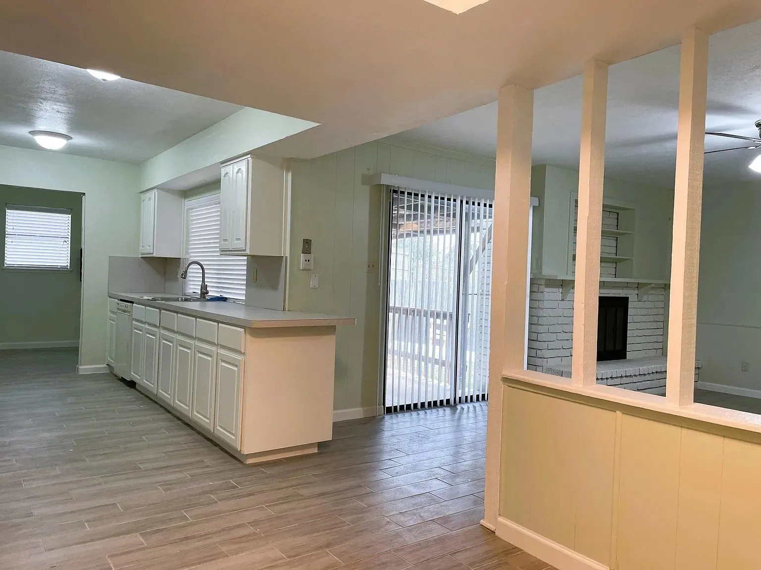 Kitchen with white cabinetry, stainless steel sink, and light-colored countertops
