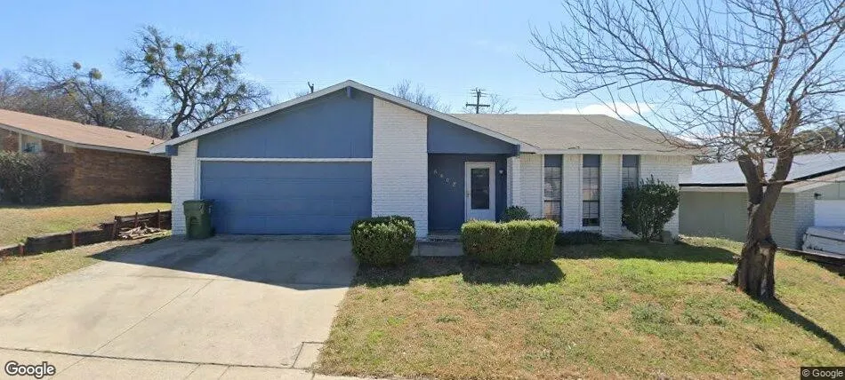 Single-story residence featuring a blue and white exterior, an attached garage, a concrete driveway, and front landscaping