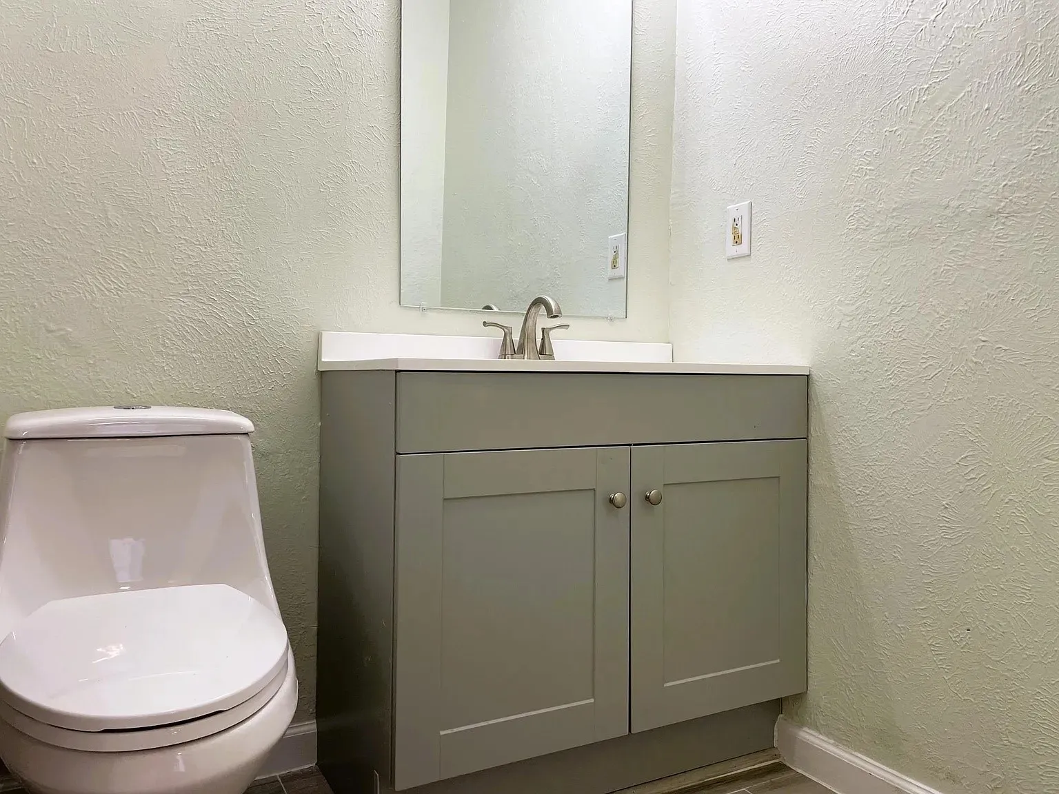 Contemporary vanity with a neutral countertop, undermount sink, and brushed nickel faucet
