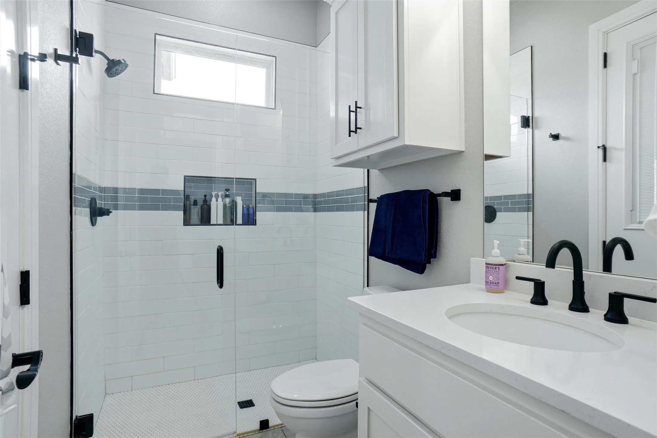 Glass-enclosed shower with subway tile and mosaic accent, access to the backyard would make this a wonderful pool bath