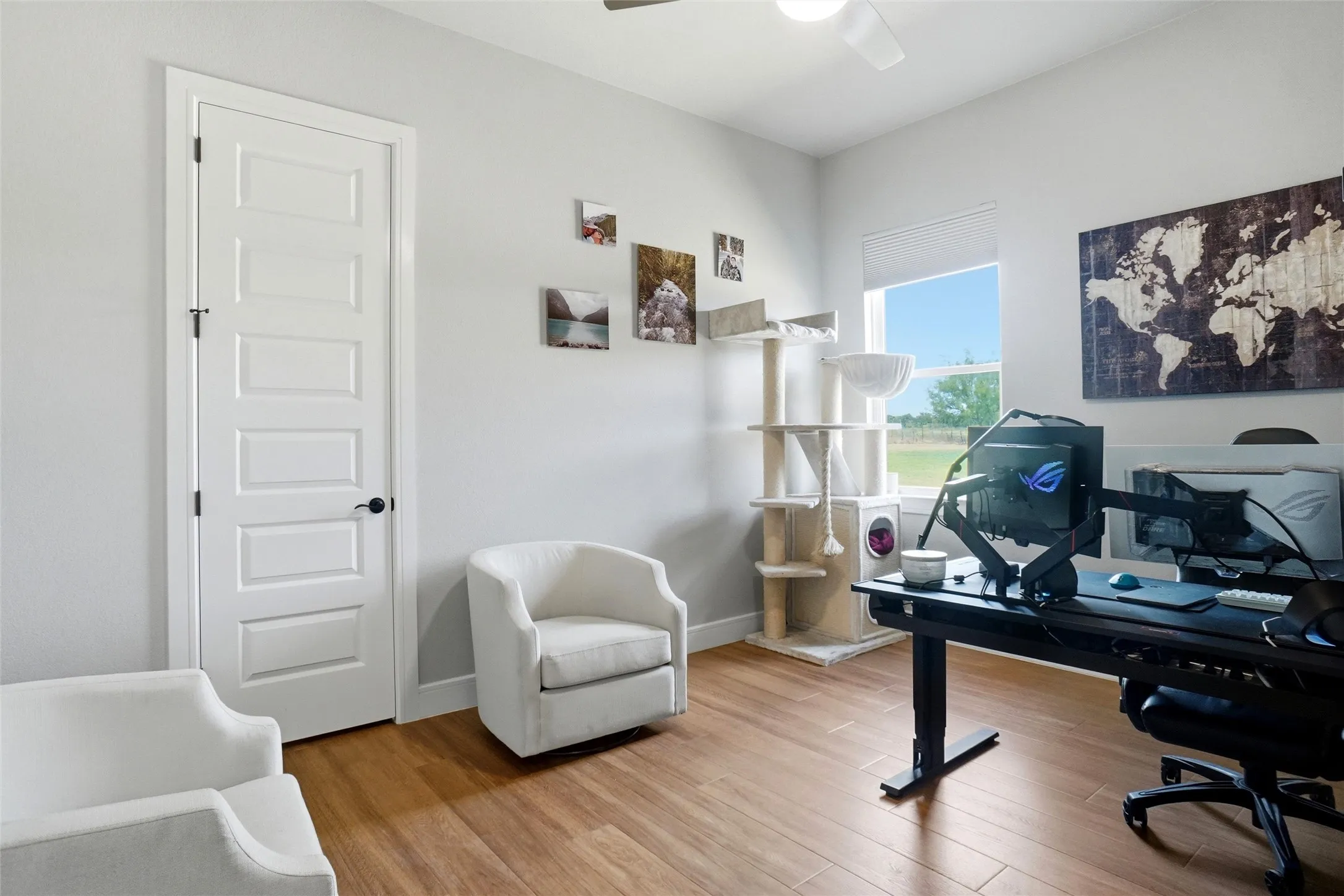 Hardwood-finish flooring, white paneled door with black hardware, recessed lighting, and a ceiling fan
