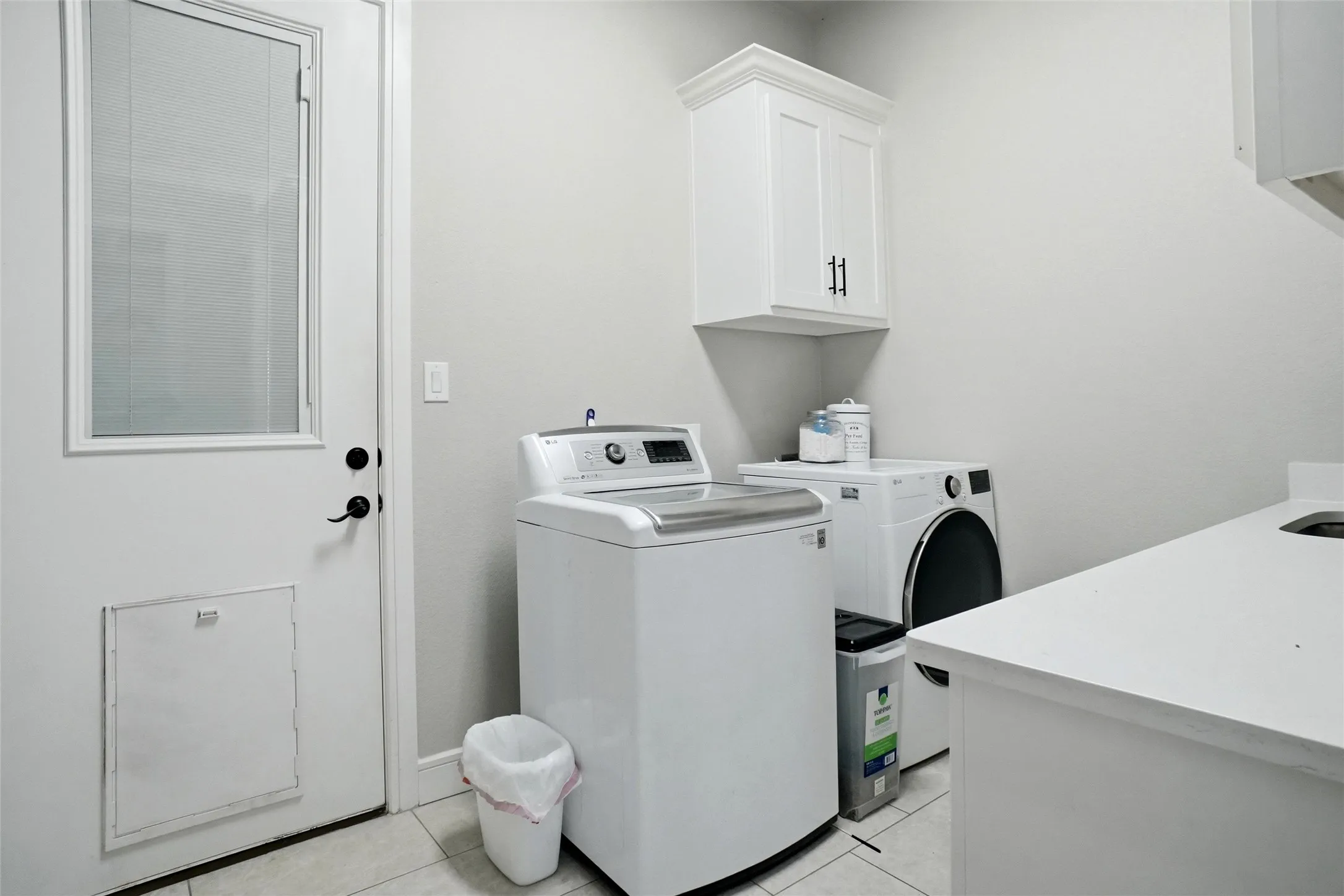 Laundry features cabinets, a sink and plenty of counter and storage space
