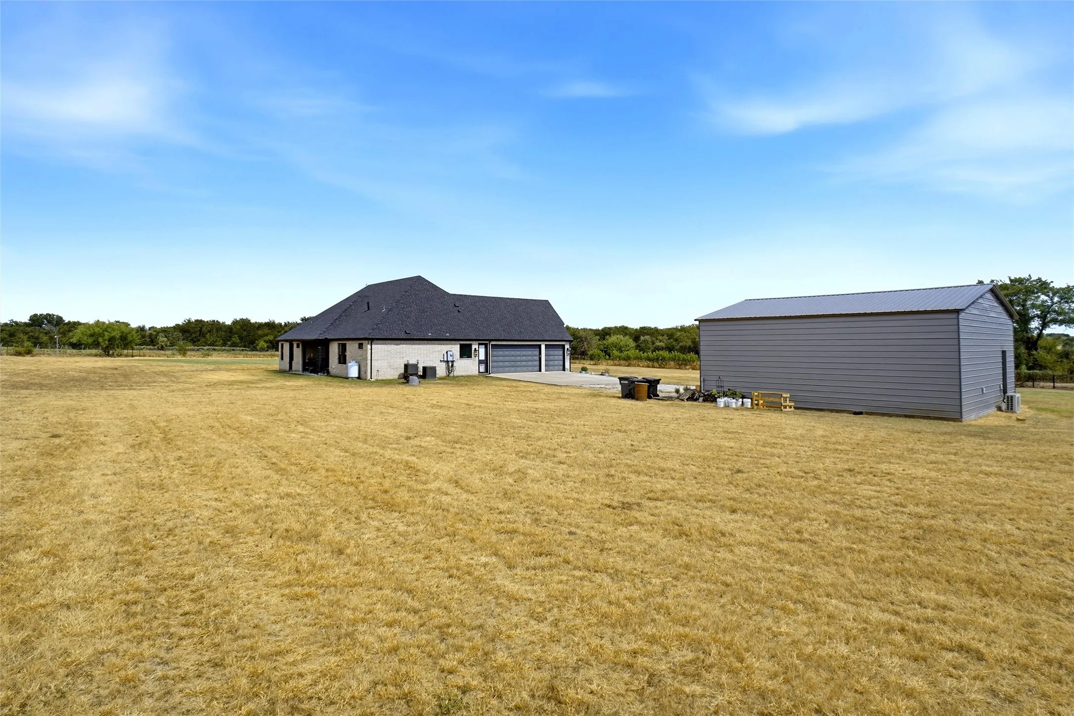 Single-story residence featuring a dark shingle roof and a three-car attached garage
