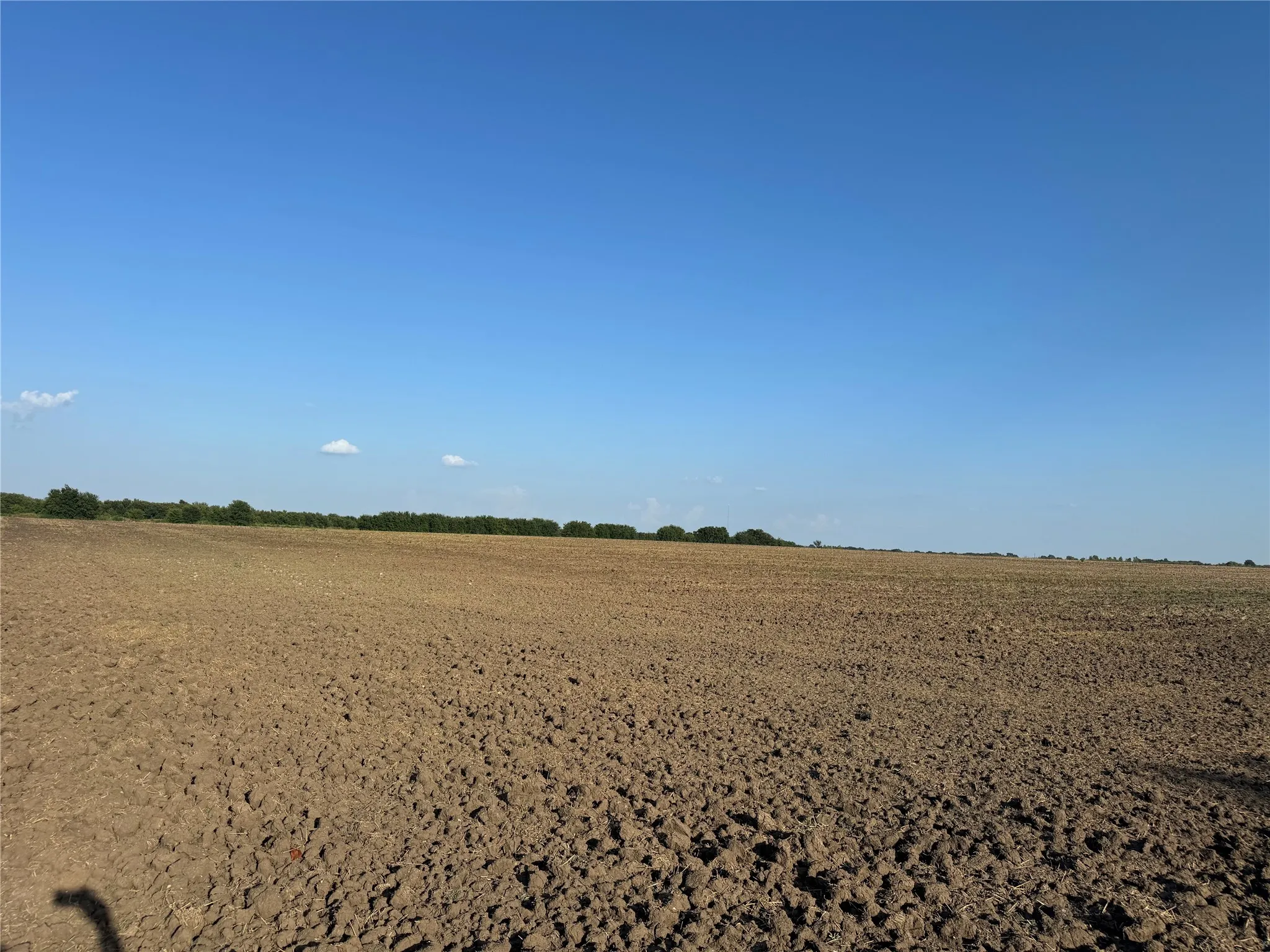 Expansive tilled agricultural land under a clear sky
