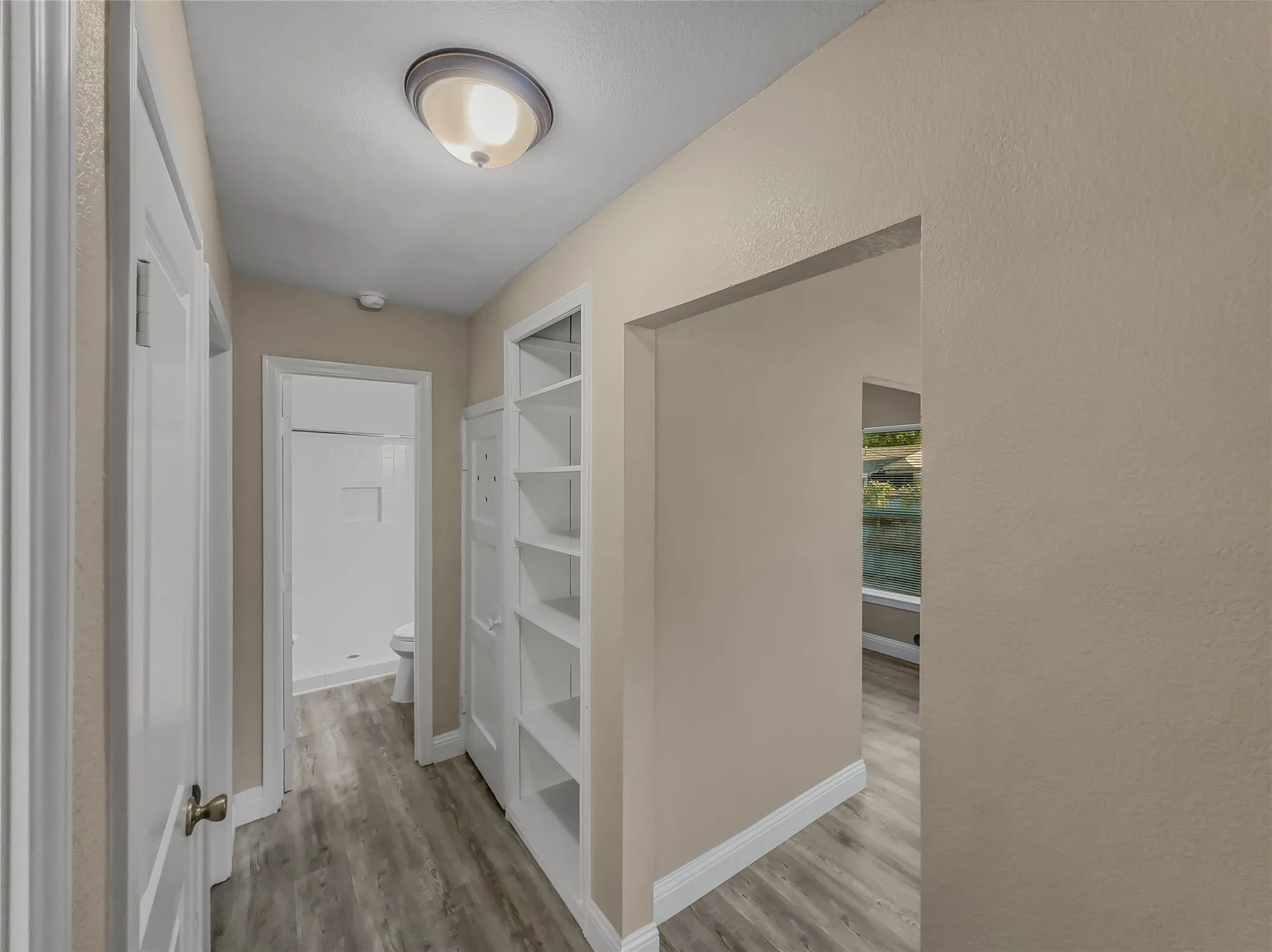 Wood-finish flooring throughout, complemented by a flush mount ceiling light fixture