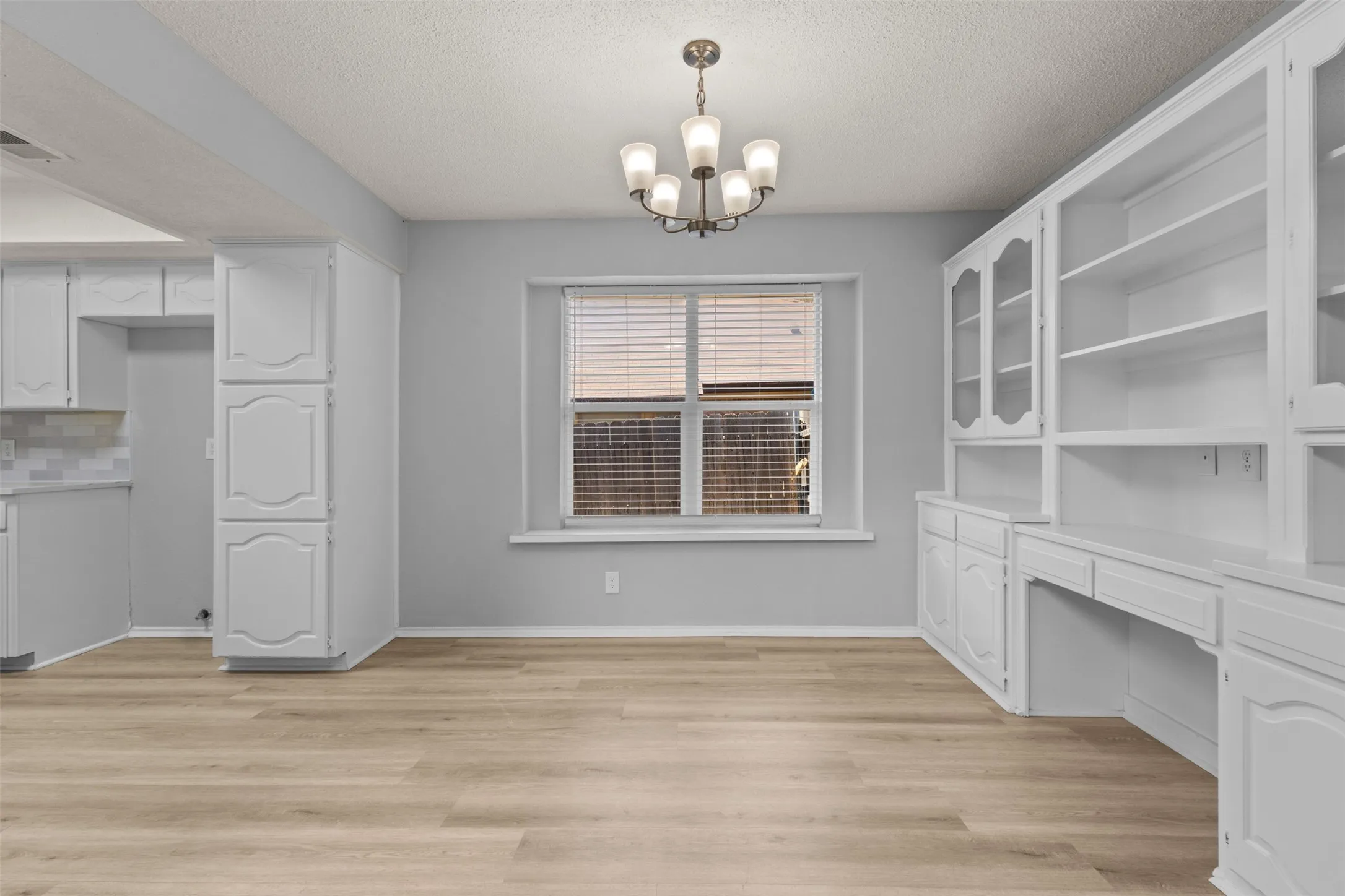 Wood-finish flooring throughout, with a window featuring blinds