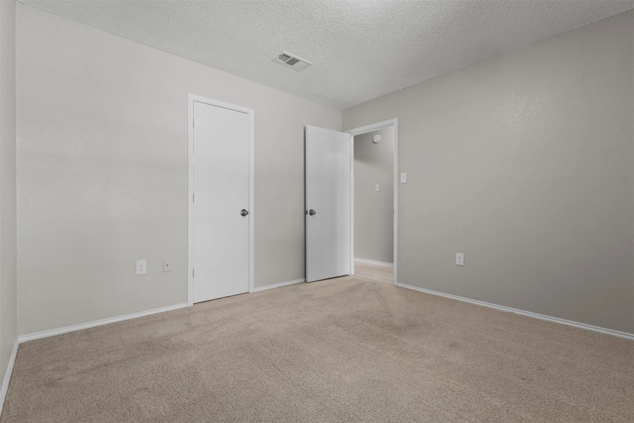 Carpeted flooring with painted walls, a white ceiling, and white trim